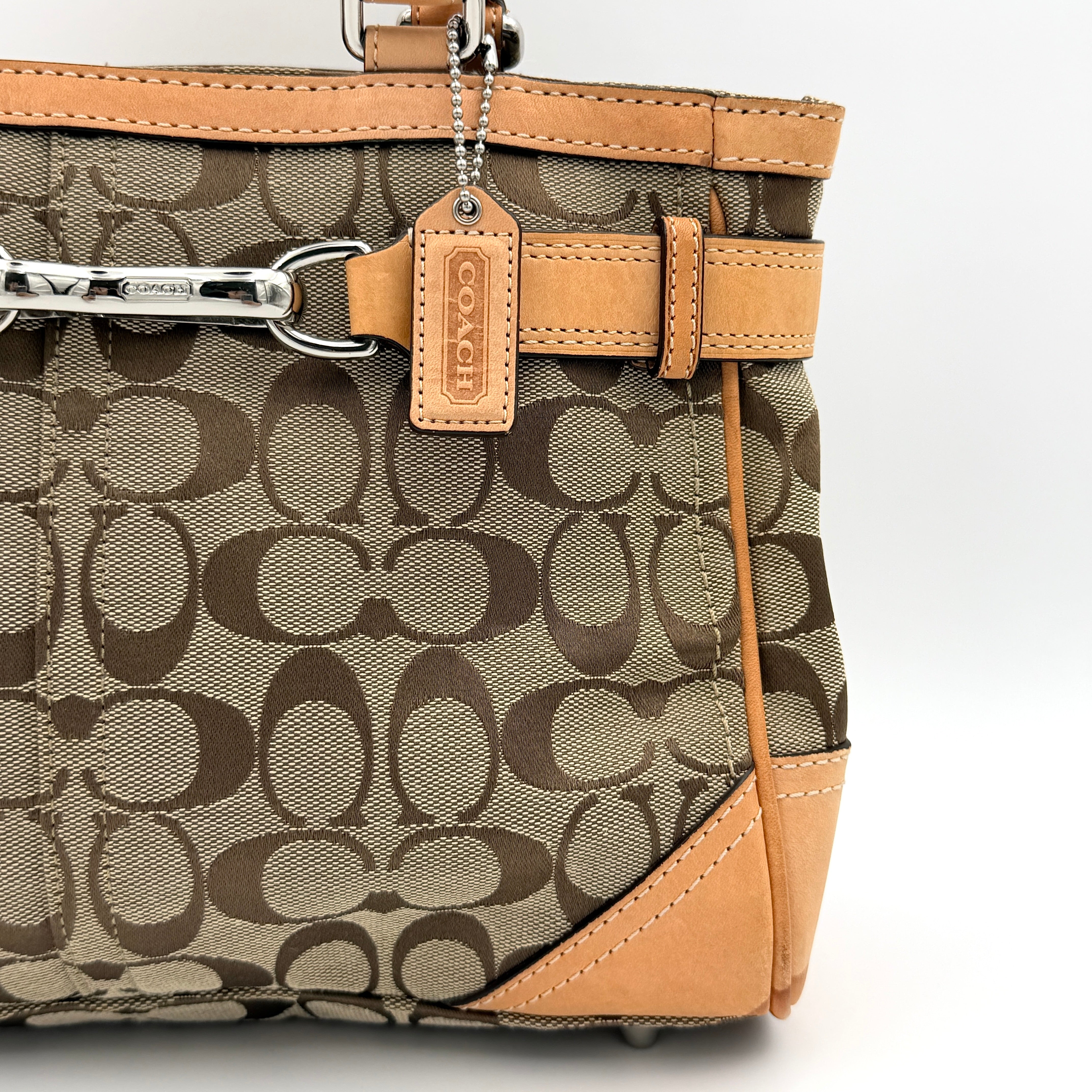 Coach Signature Hampton Clip Shoulder Bag in beige and brown jacquard canvas with leather trim and silver-tone hardware, displayed upright with twin handles.