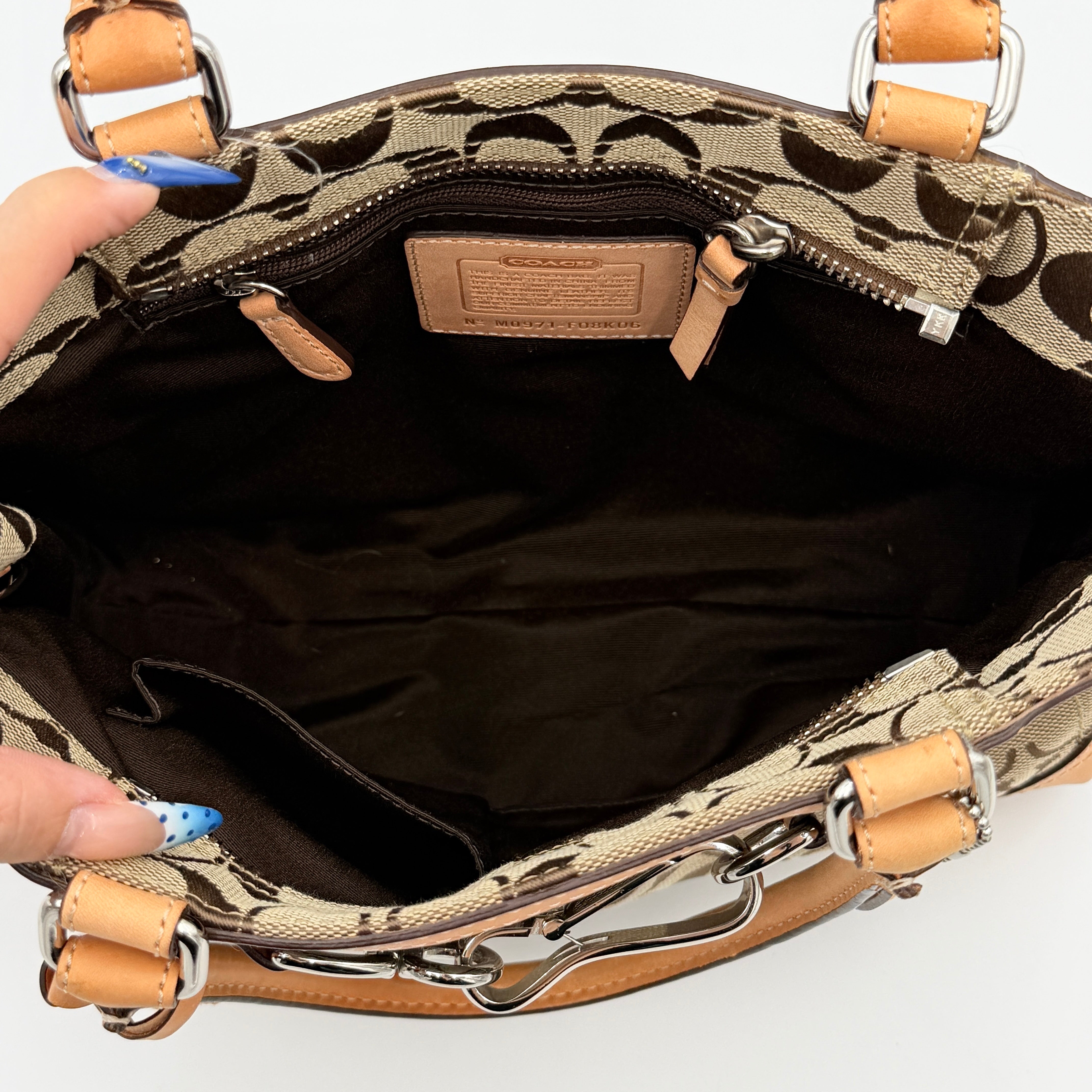 Coach Signature Hampton Clip Shoulder Bag in beige and brown jacquard canvas with leather trim and silver-tone hardware, displayed upright with twin handles.
