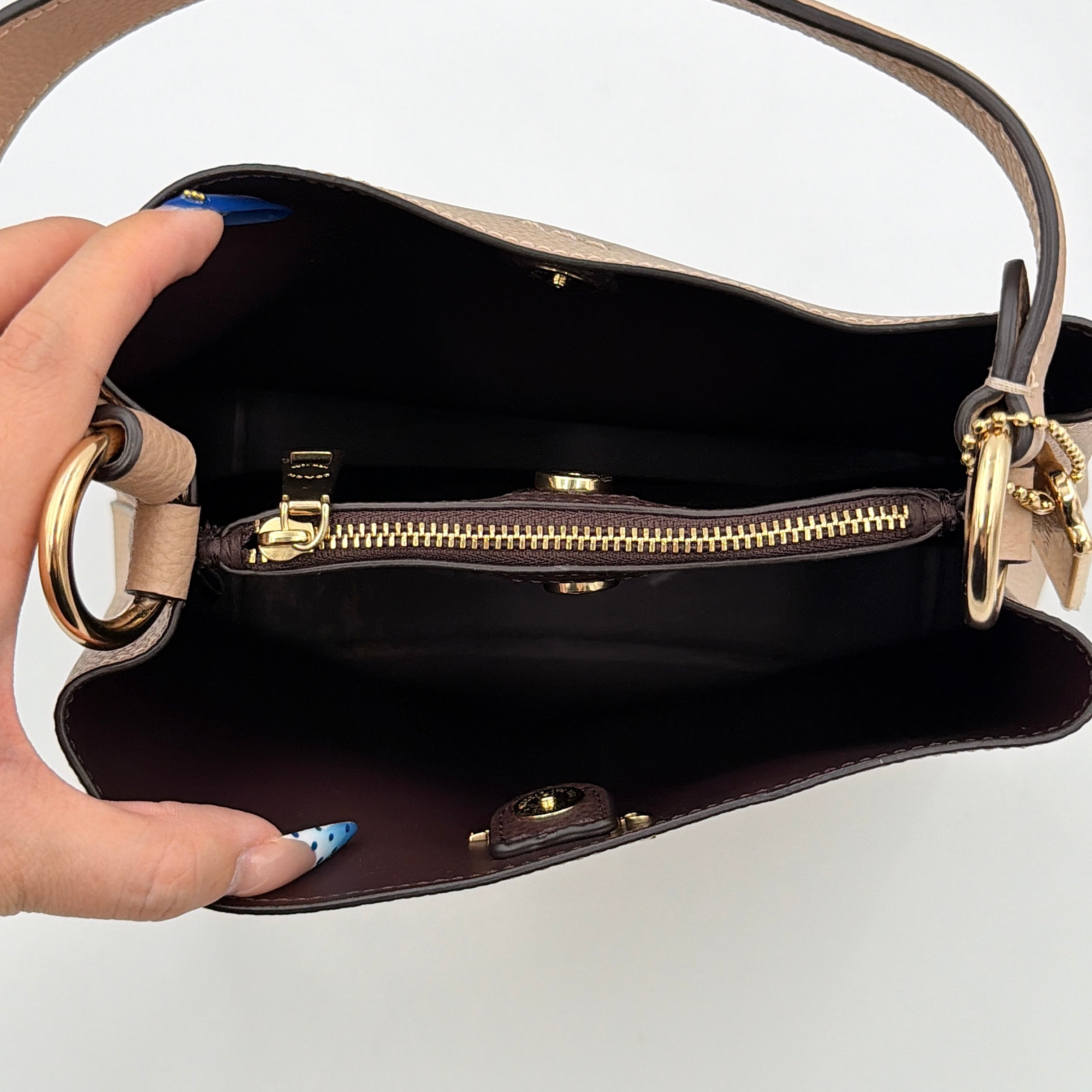 Coach Town Bucket Bag in taupe pebbled leather with gold-tone hardware and Coach hangtag, shown against a white background.