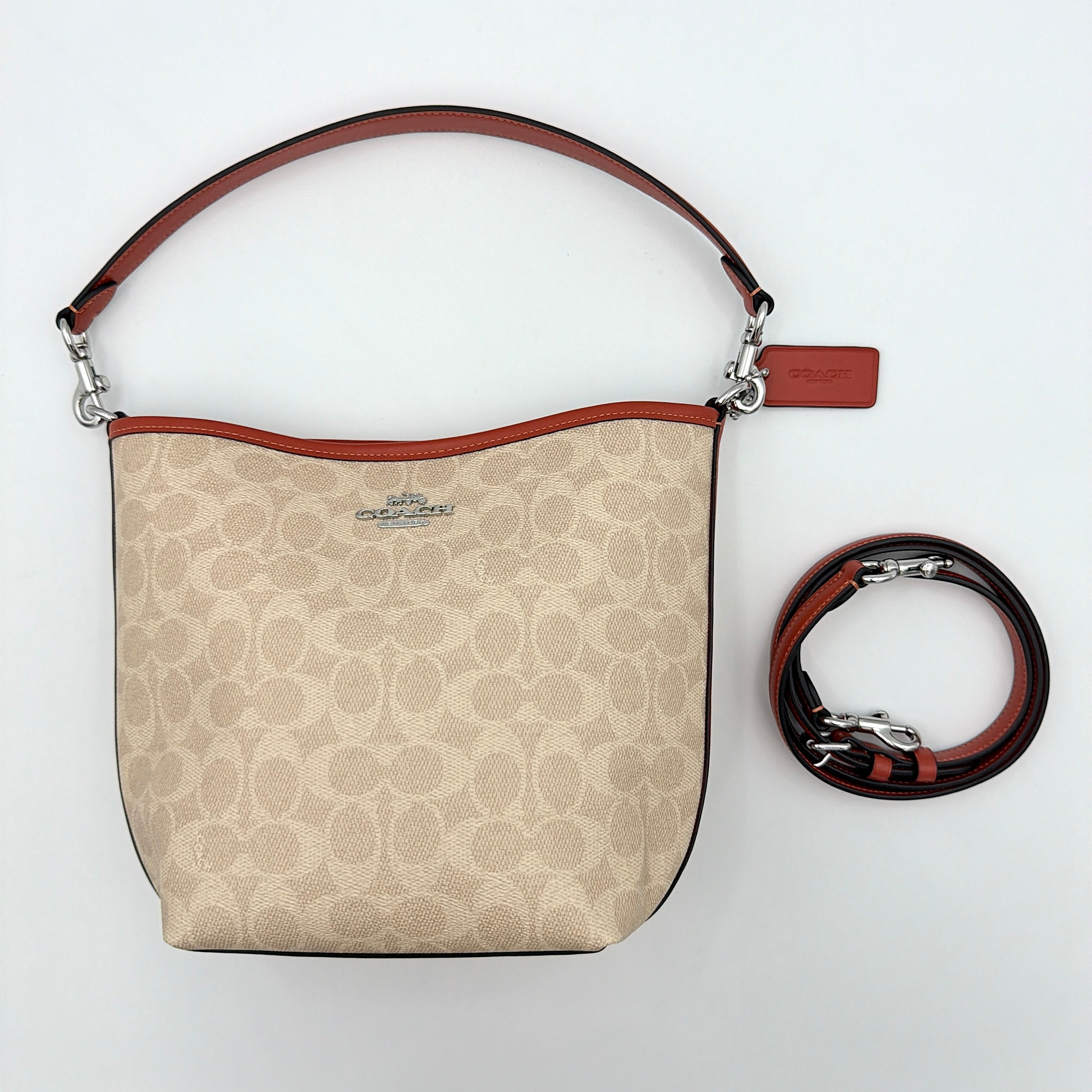 Coach 2Way City Bucket Shoulder Bag in beige signature canvas with red leather accents, detachable strap, and silver-tone hardware.