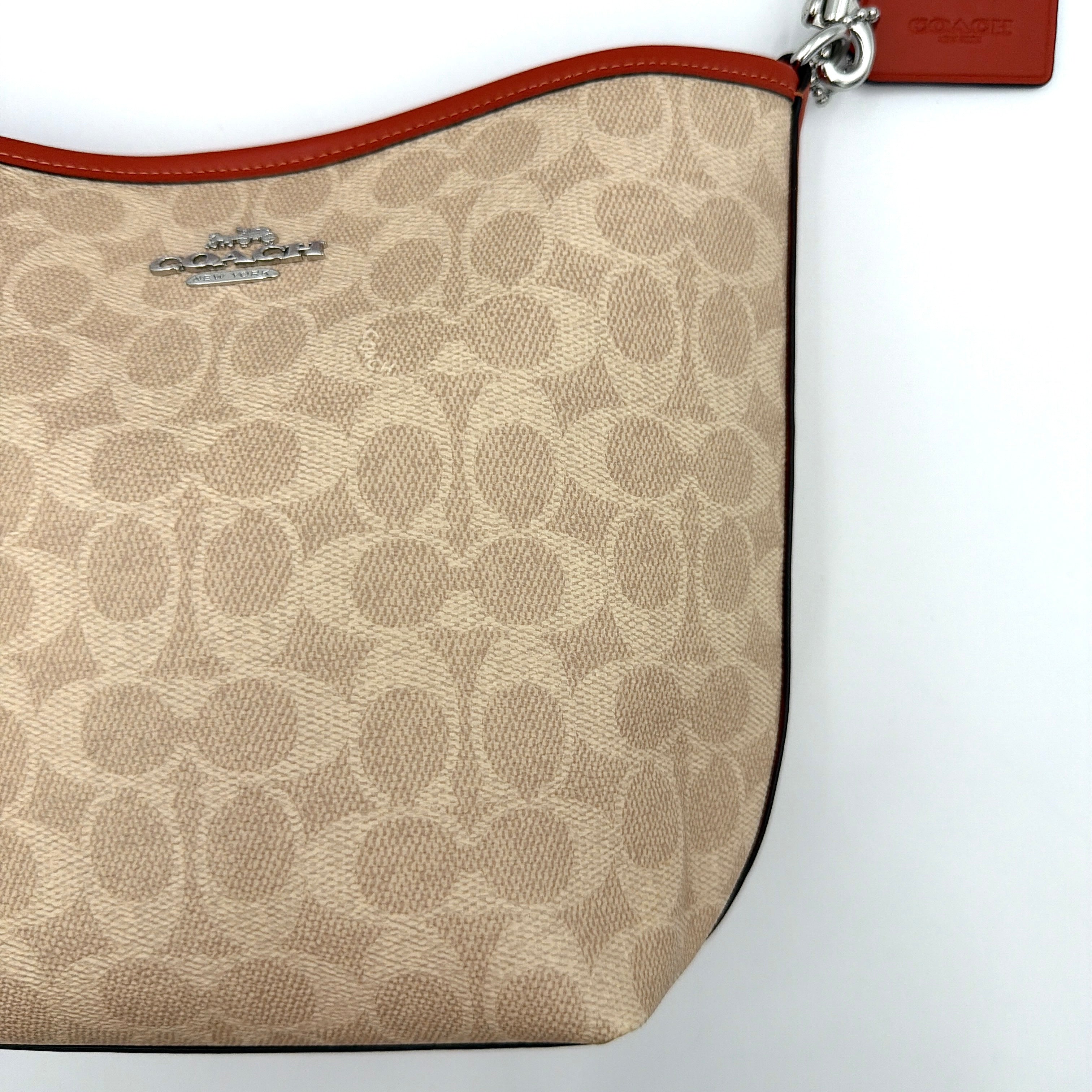 Coach 2Way City Bucket Shoulder Bag in beige signature canvas with red leather accents, detachable strap, and silver-tone hardware.