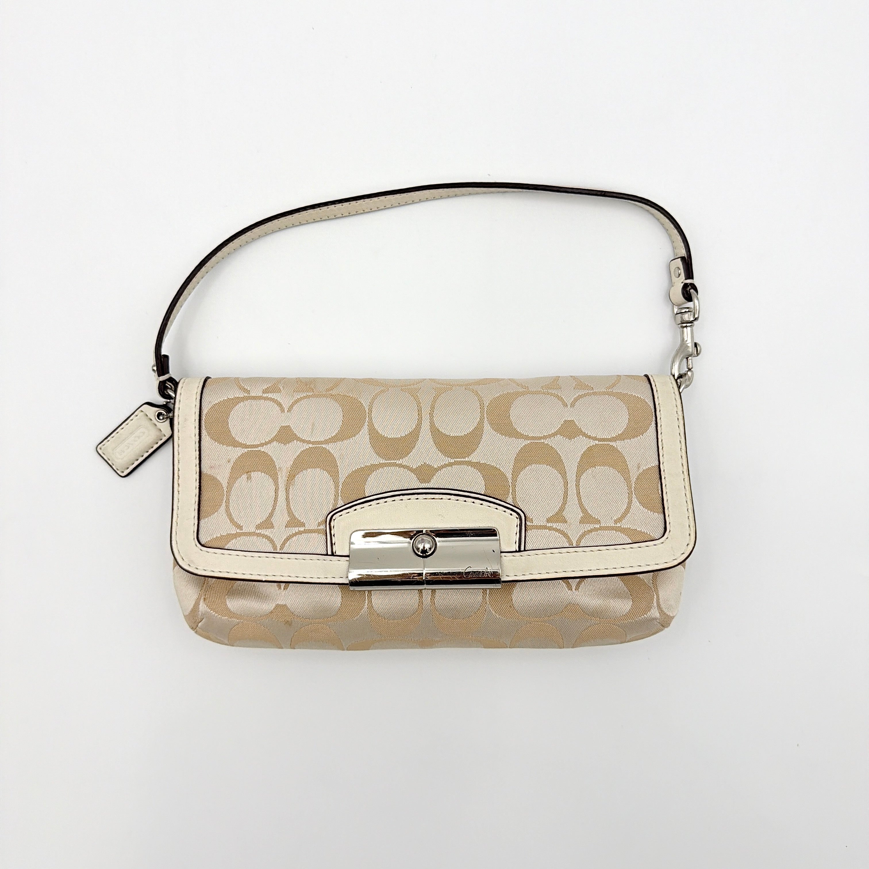 Coach Signature Kristin Shoulder Bag in beige and white jacquard canvas with white leather trim, presented with a polished silver push-lock clasp.
