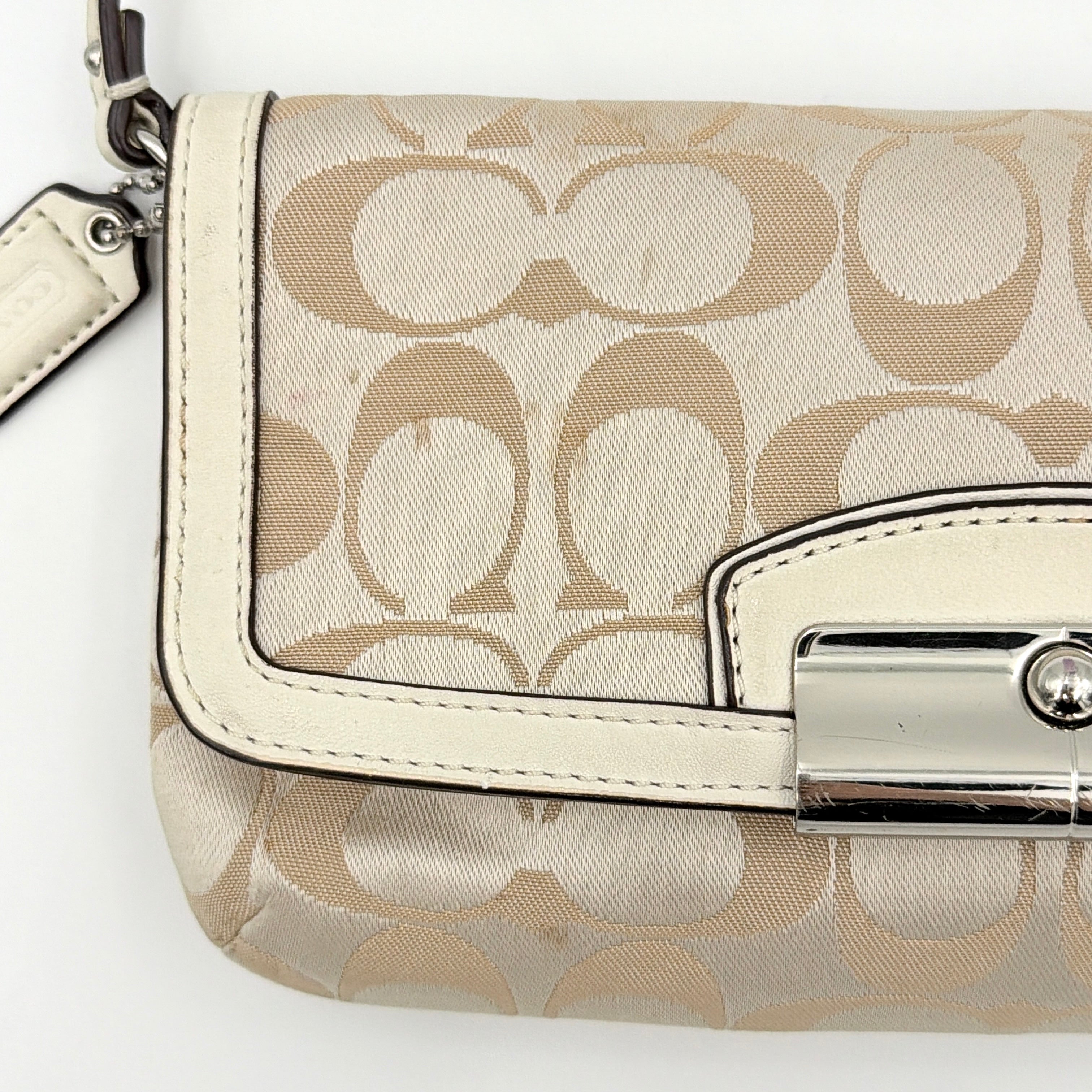 Coach Signature Kristin Shoulder Bag in beige and white jacquard canvas with white leather trim, presented with a polished silver push-lock clasp.