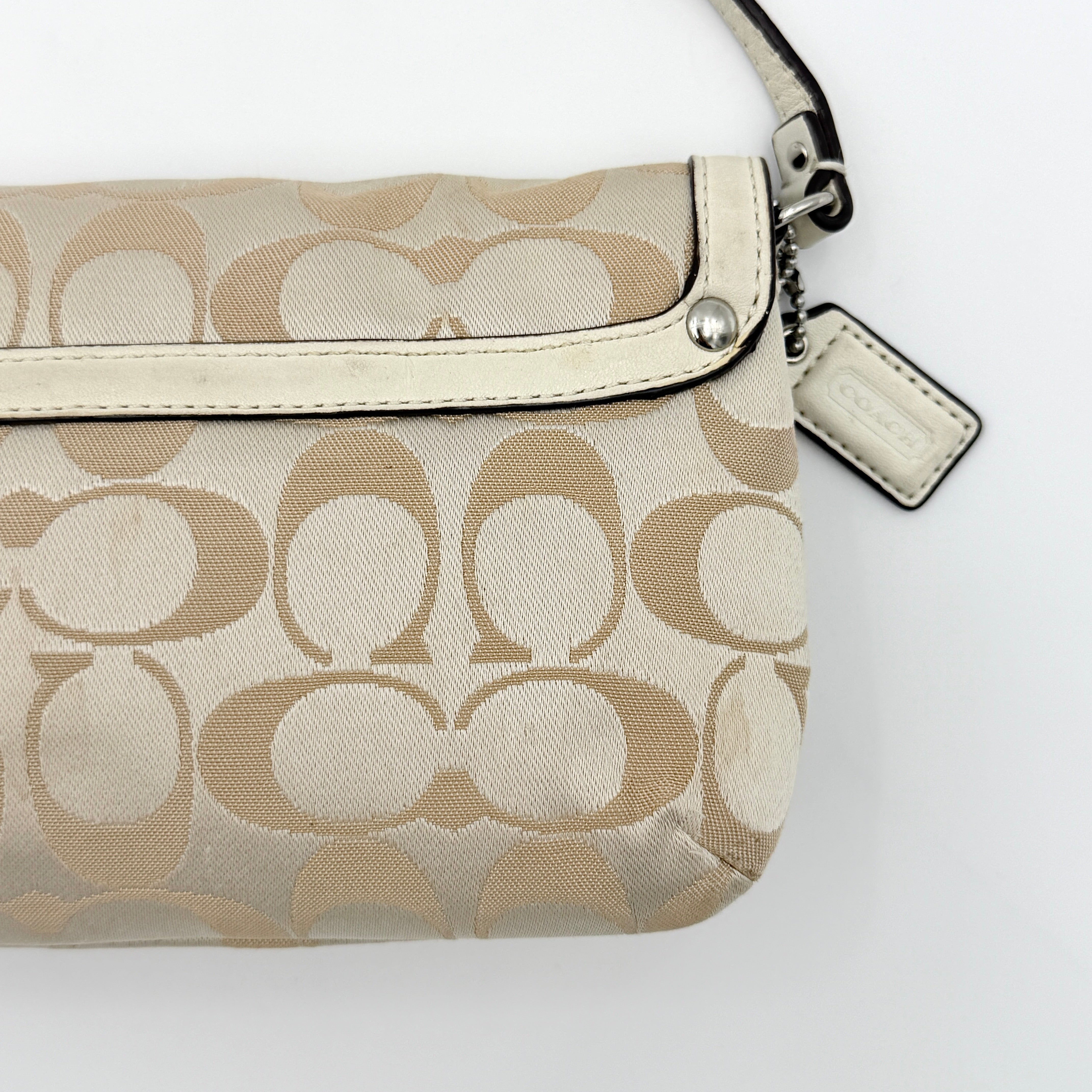 Coach Signature Kristin Shoulder Bag in beige and white jacquard canvas with white leather trim, presented with a polished silver push-lock clasp.