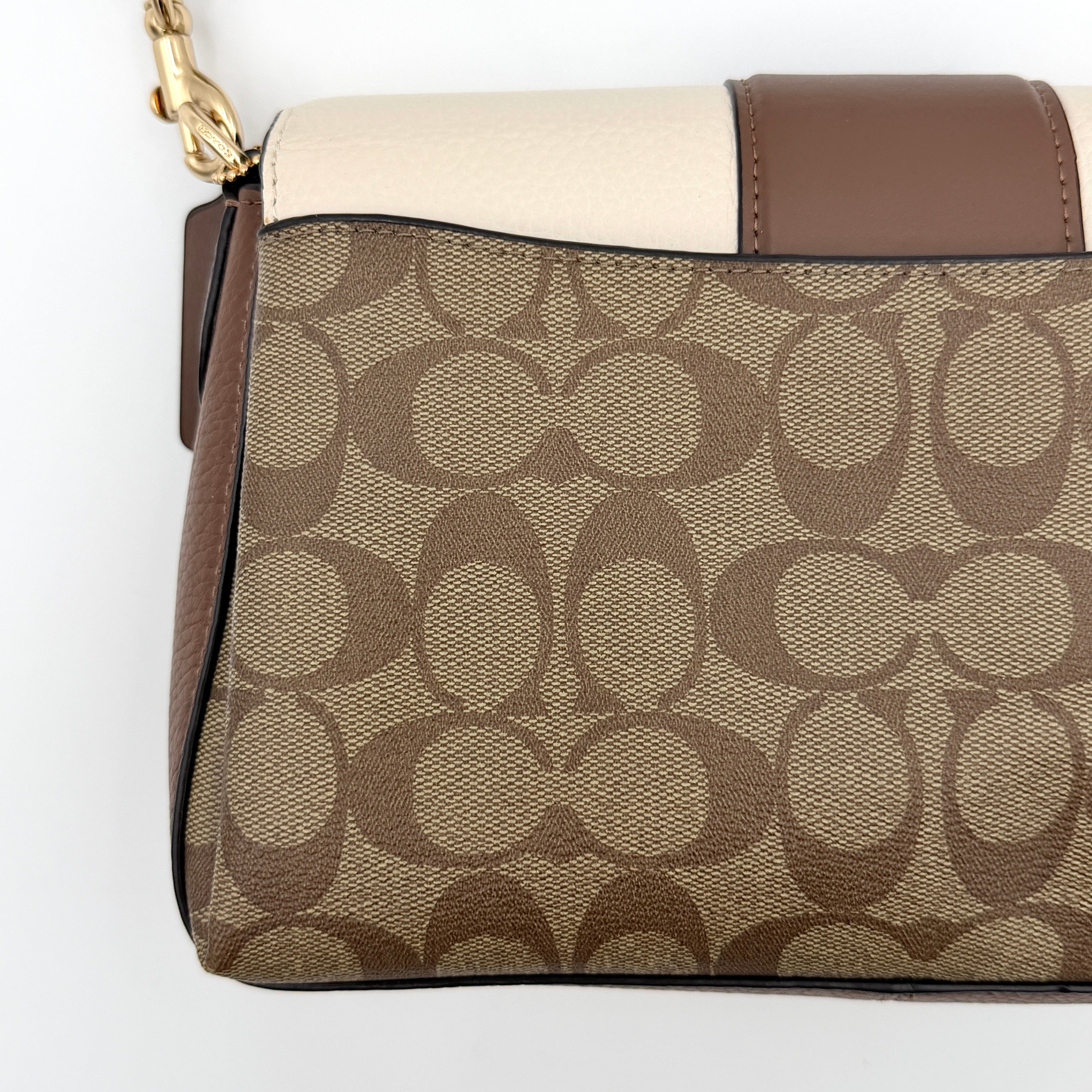 Coach Signature Grace Shoulder Bag in beige and white leather with monogram canvas and gold hardware, displayed with structured silhouette and top handle.