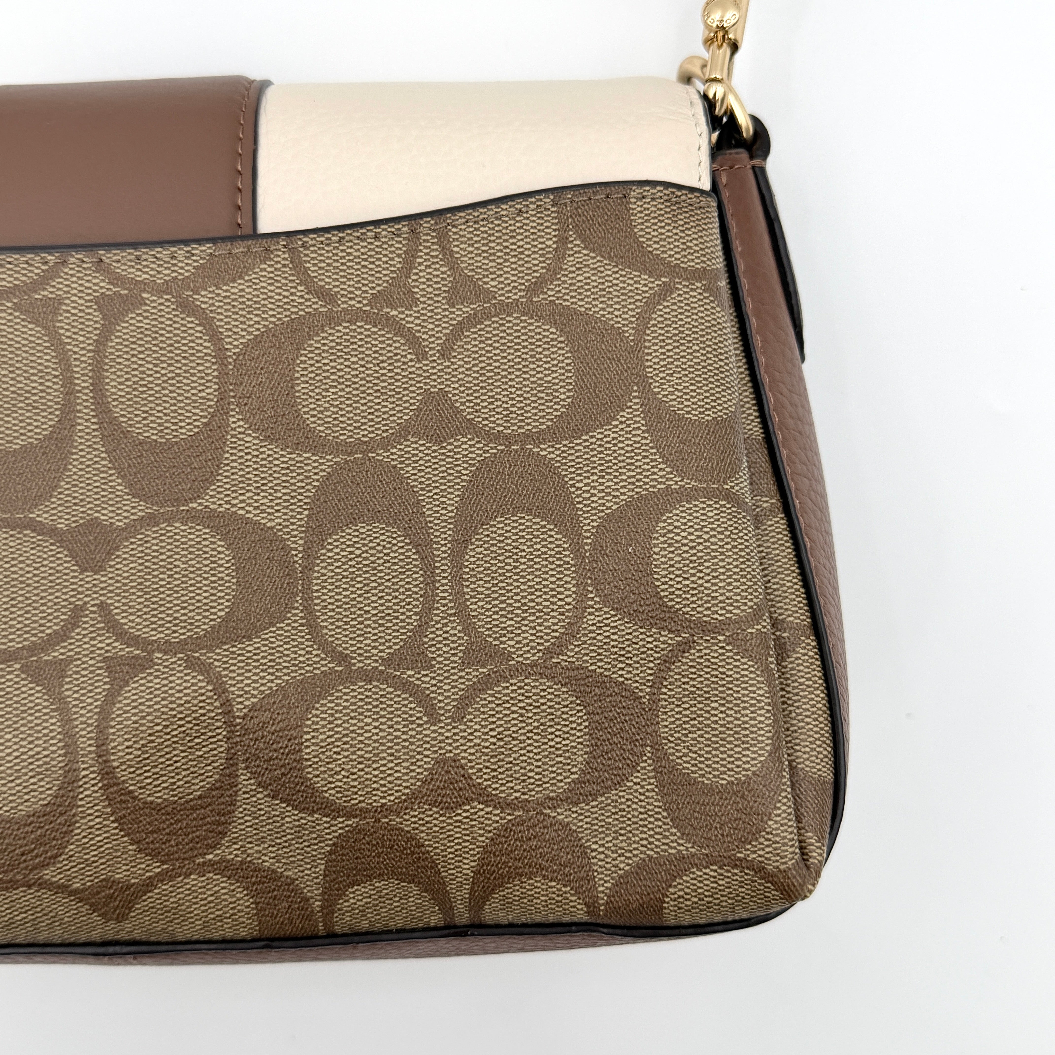 Coach Signature Grace Shoulder Bag in beige and white leather with monogram canvas and gold hardware, displayed with structured silhouette and top handle.