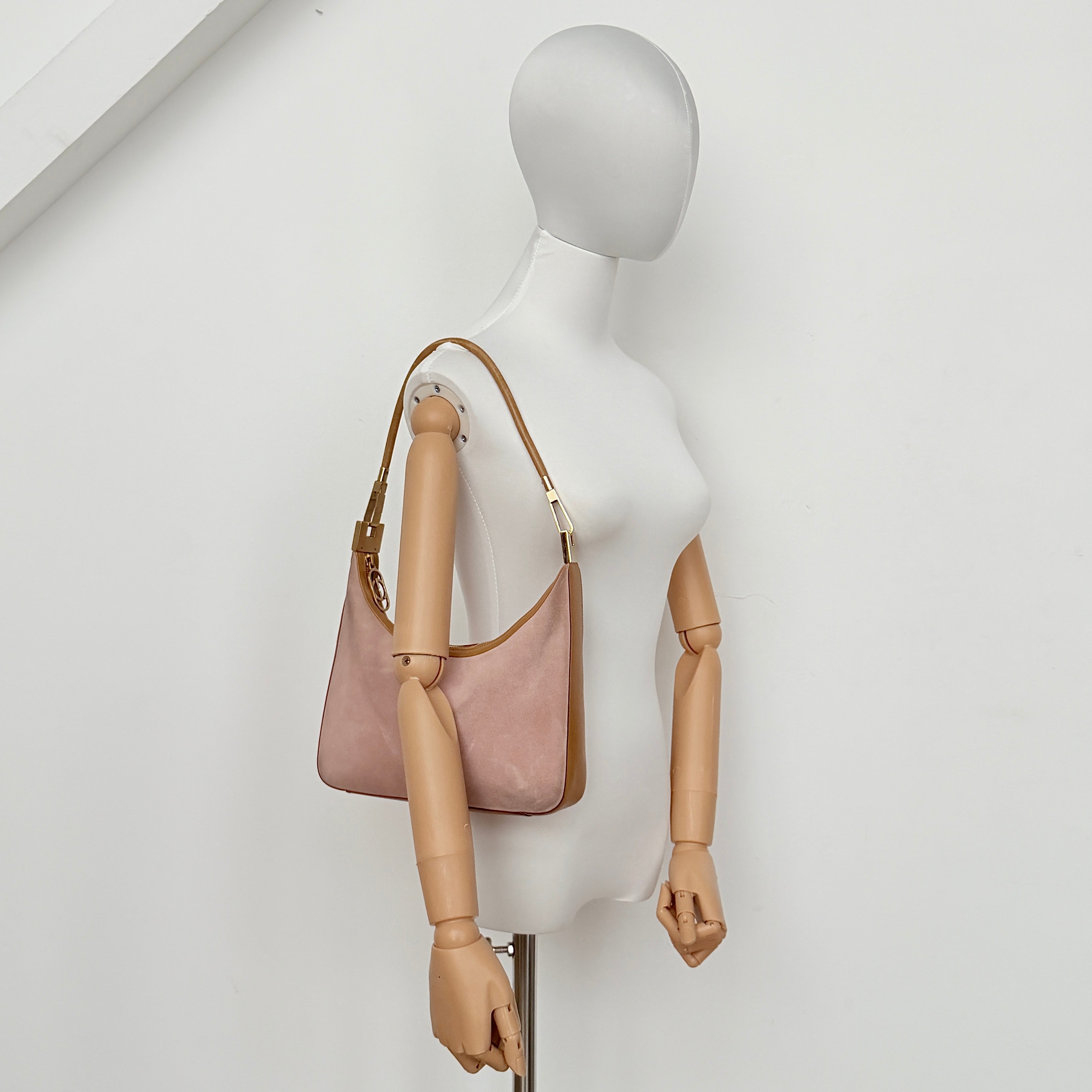 Gucci hobo shoulder bag in blush pink suede with tan leather trim and gold hardware, displayed against a white background.