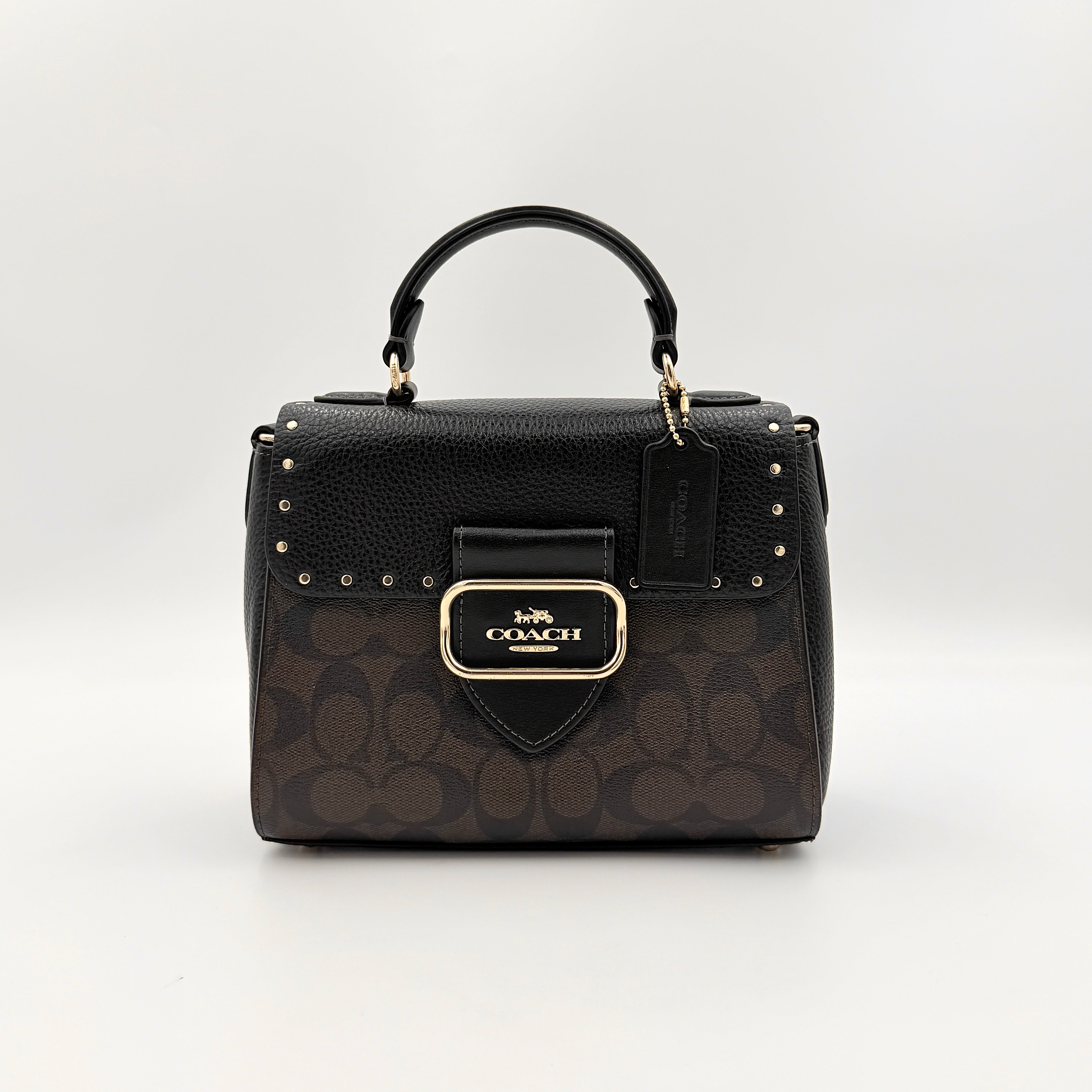 Coach Morgan Top Handle Bag in brown and black signature canvas with pebbled leather, gold hardware and detachable strap displayed alongside a Coach dustbag.