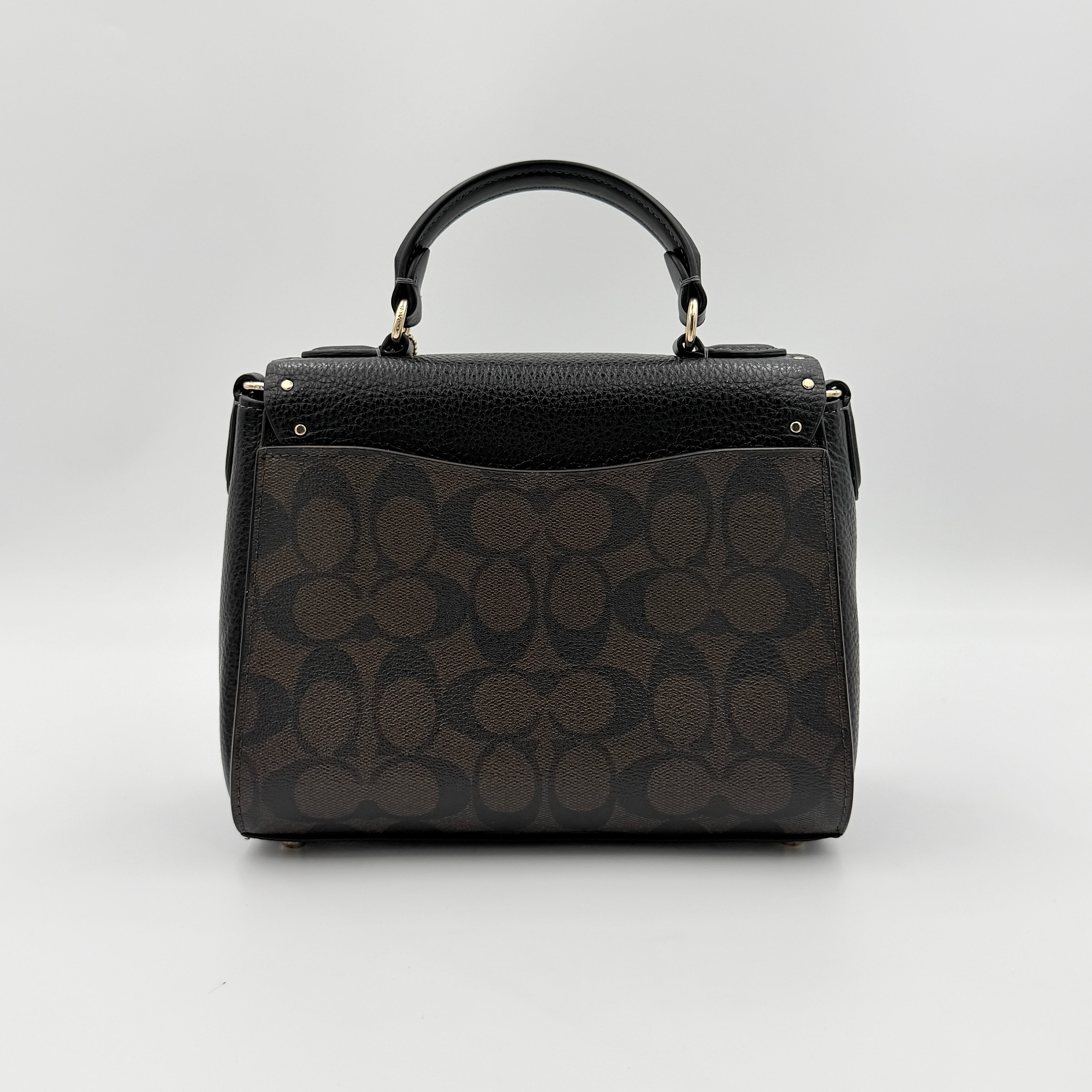 Coach Morgan Top Handle Bag in brown and black signature canvas with pebbled leather, gold hardware and detachable strap displayed alongside a Coach dustbag.