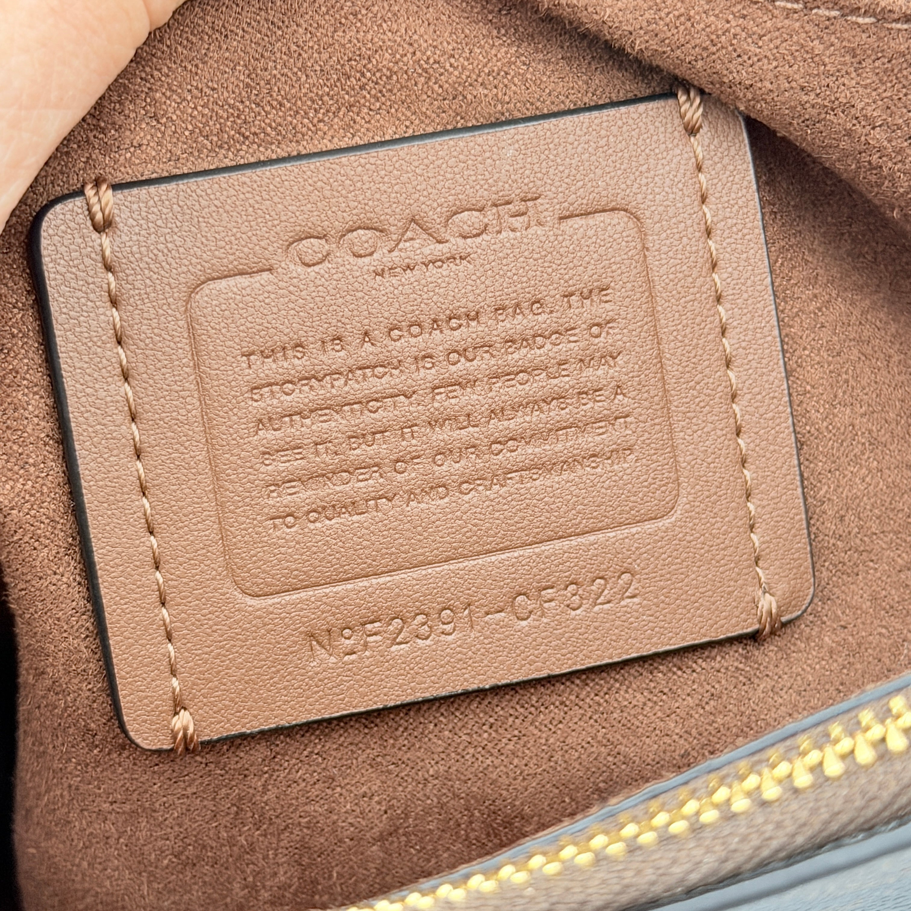 Coach Morgan Top Handle Bag in brown and black signature canvas with pebbled leather, gold hardware and detachable strap displayed alongside a Coach dustbag.