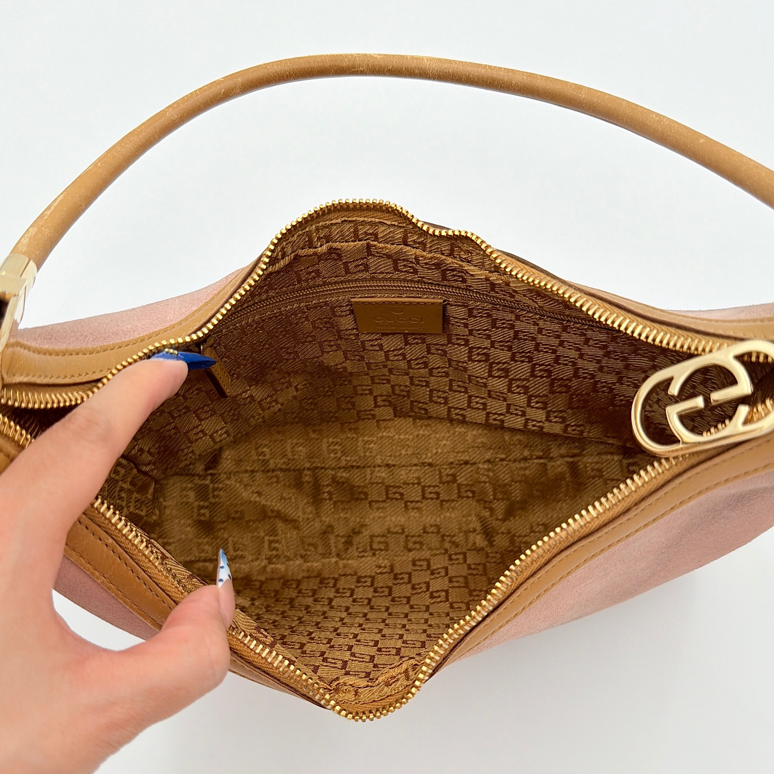 Gucci hobo shoulder bag in blush pink suede with tan leather trim and gold hardware, displayed against a white background.