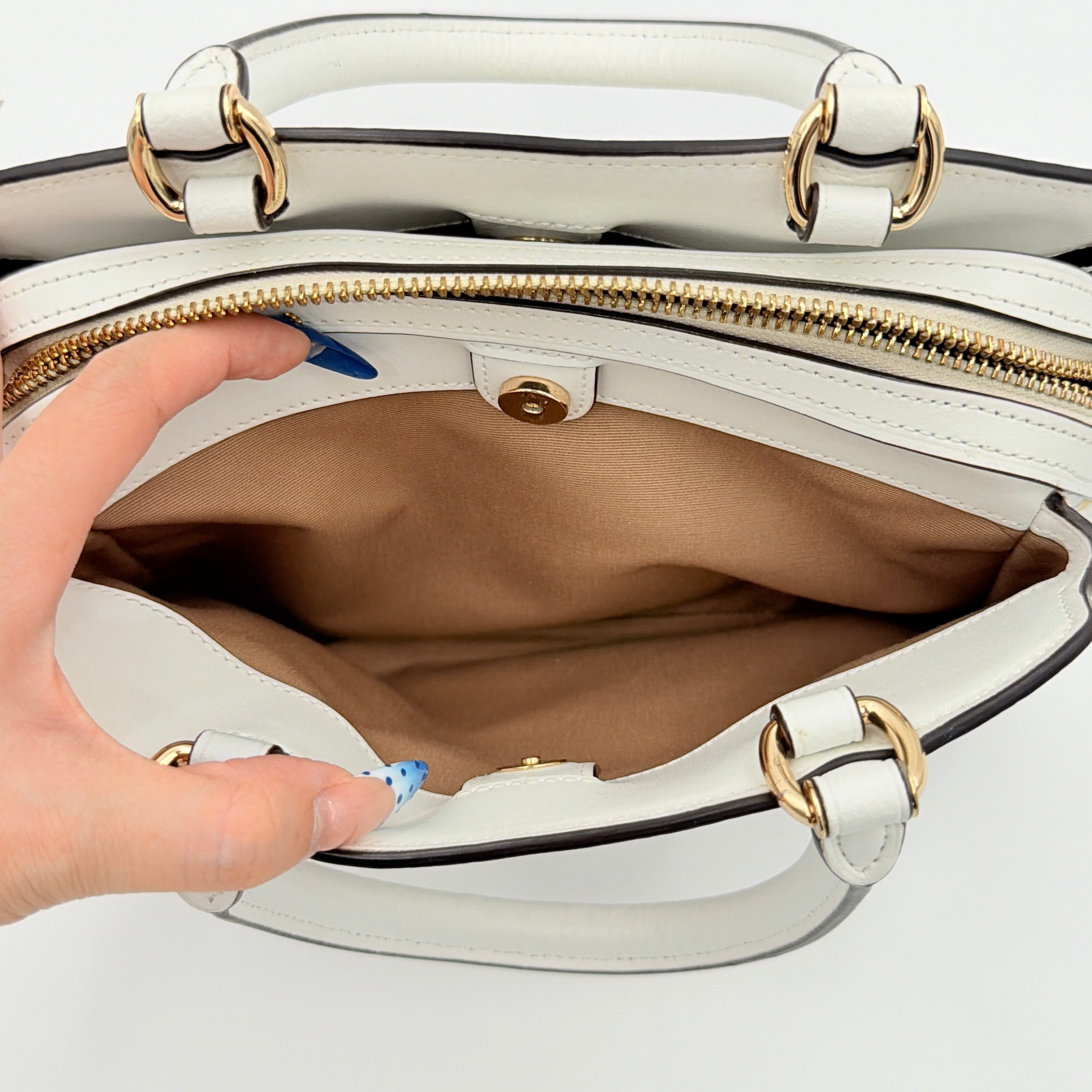 Coach 2Way Signature Lillie Carryall in white canvas with gold hardware and multicolour floral print, accompanied by a detachable white shoulder strap.