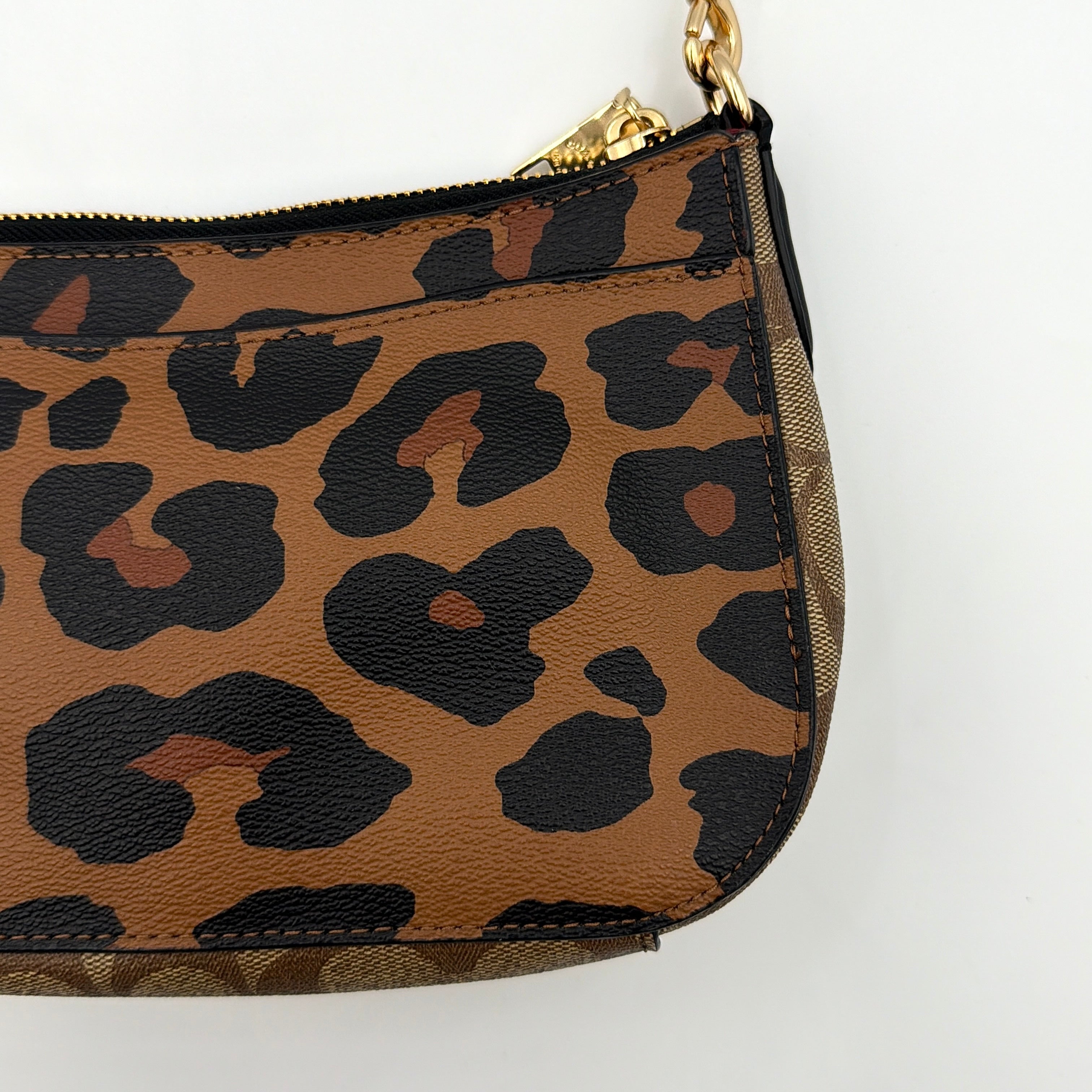 Coach Georgie Shoulder Bag in brown and black leopard print with gold horse and carriage medallion, displayed with its detachable chain and leather strap.