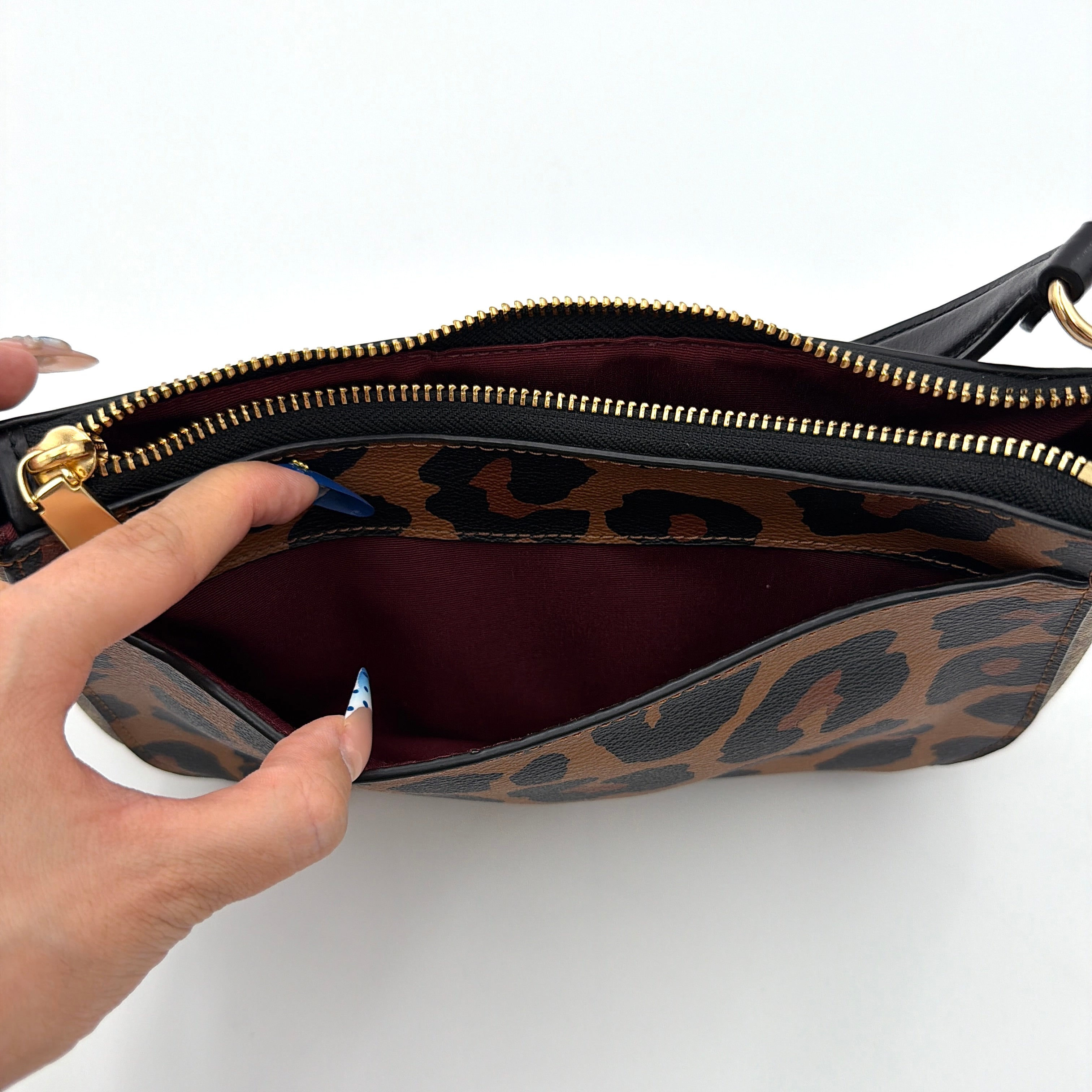 Coach Georgie Shoulder Bag in brown and black leopard print with gold horse and carriage medallion, displayed with its detachable chain and leather strap.
