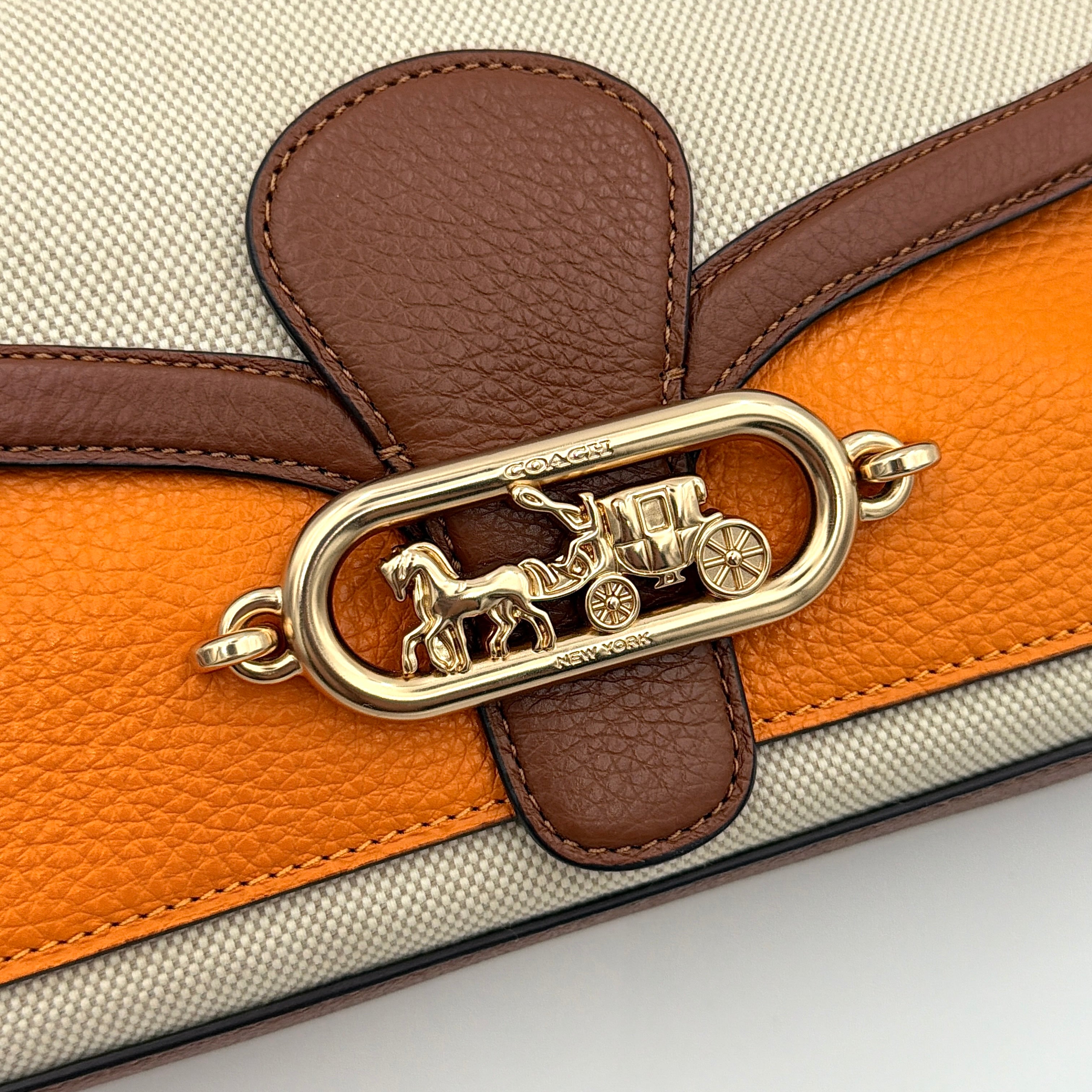 Coach Jade 2Way Shoulder Bag in sand canvas with amber and brown leather trim, gold-tone carriage hardware, and detachable strap.