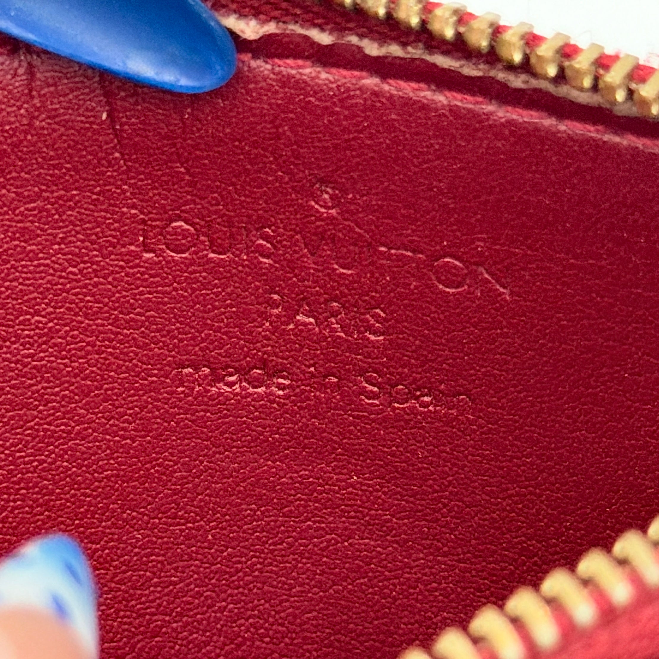 Louis Vuitton Vernis Coin Case in amethyst red patent leather with gold-tone key chain and zip closure, embossed with monogram pattern.