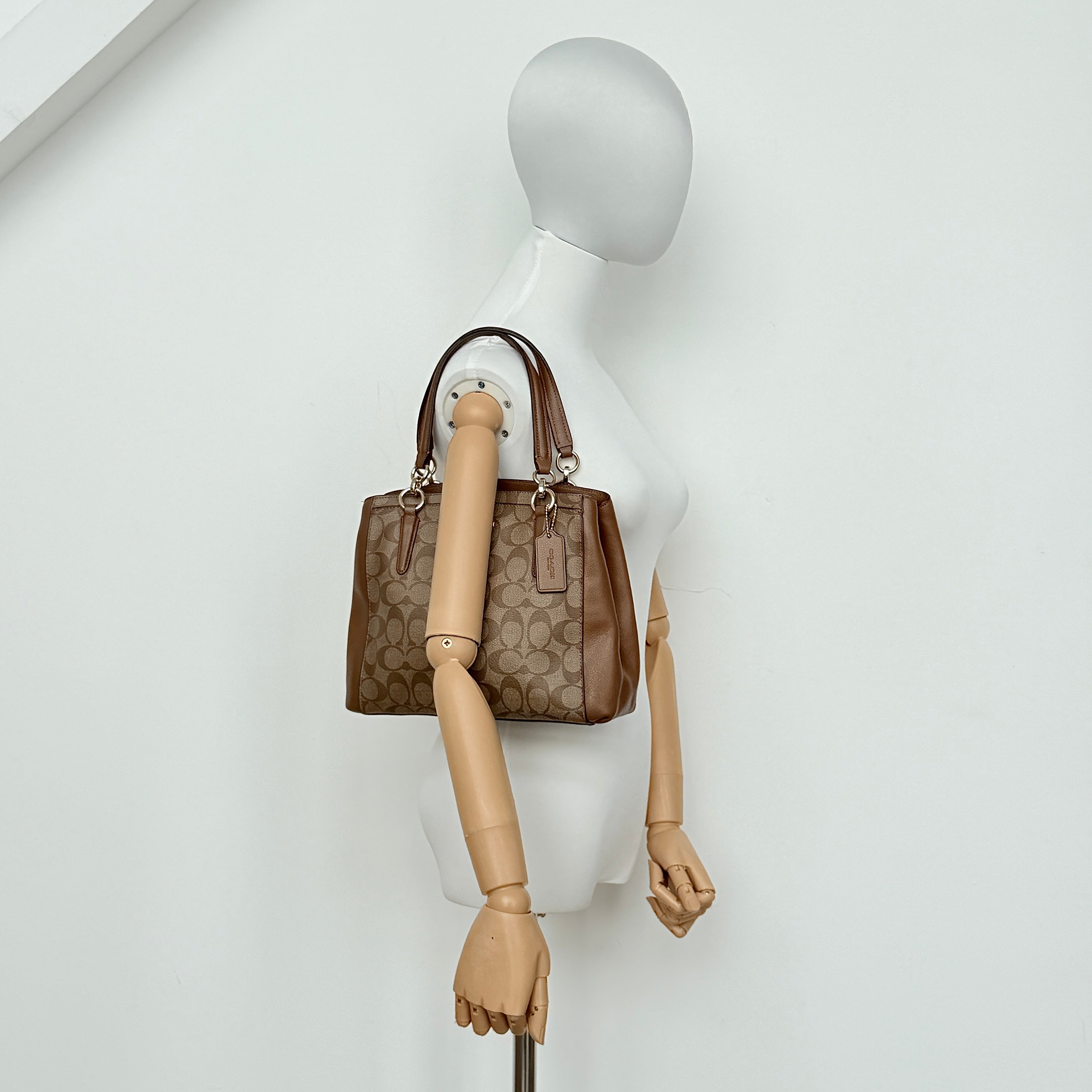 Coach Mini Christie Carryall in brown canvas and leather, shown with top handles and detachable strap.