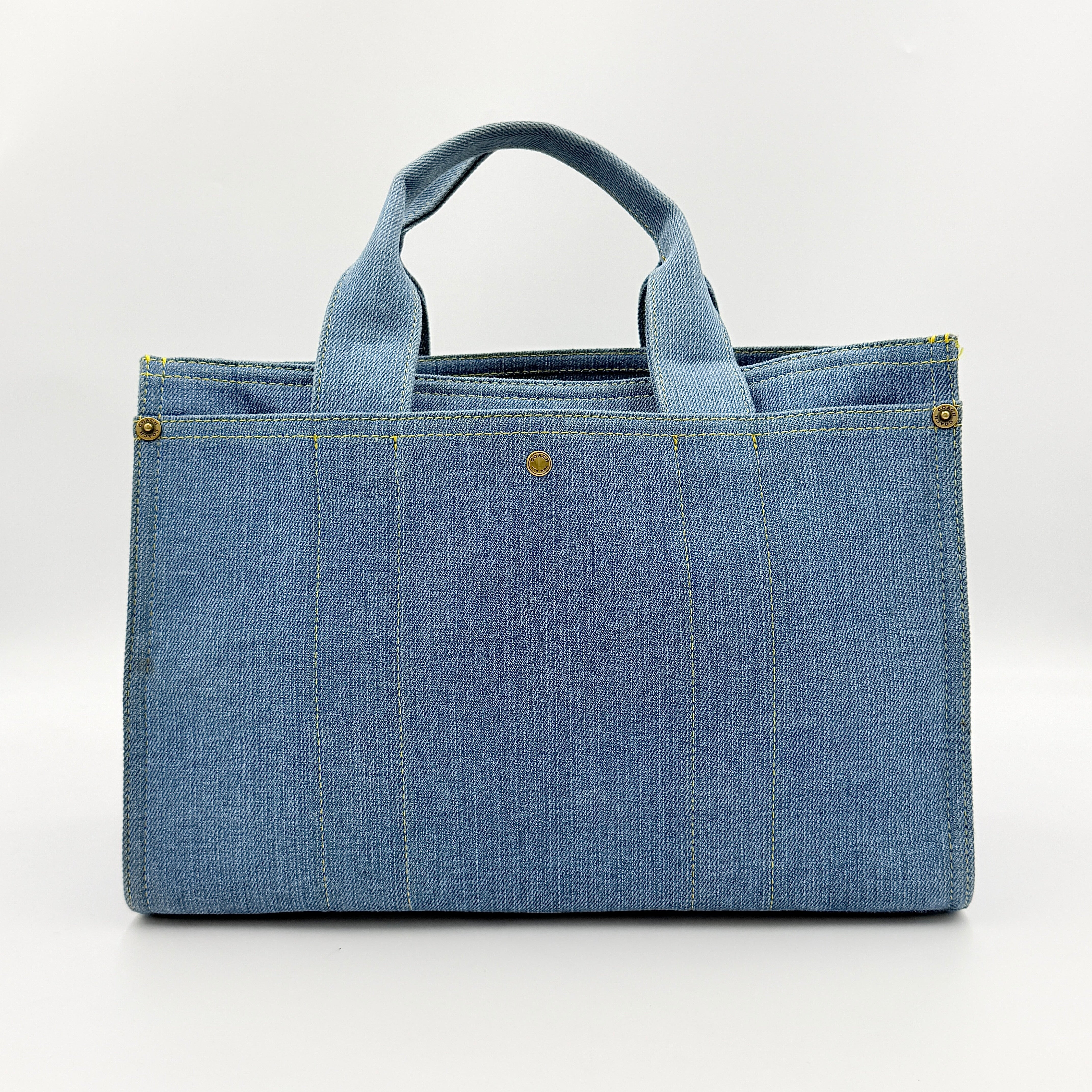 Coach denim 2Way Logo 20 Tote Bag in blue, embroidered with 'Coach New York', shown with detachable navy strap.