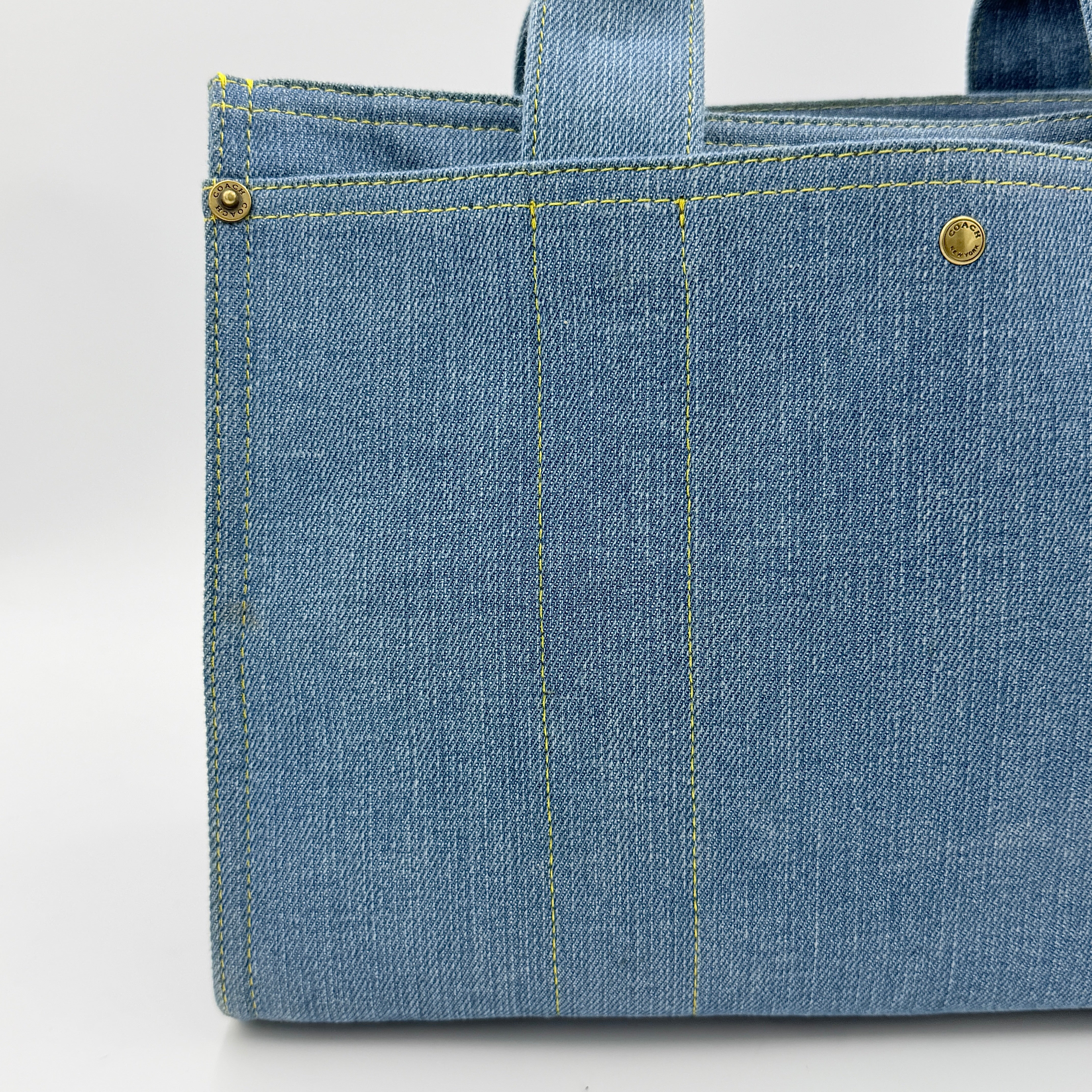 Coach denim 2Way Logo 20 Tote Bag in blue, embroidered with 'Coach New York', shown with detachable navy strap.
