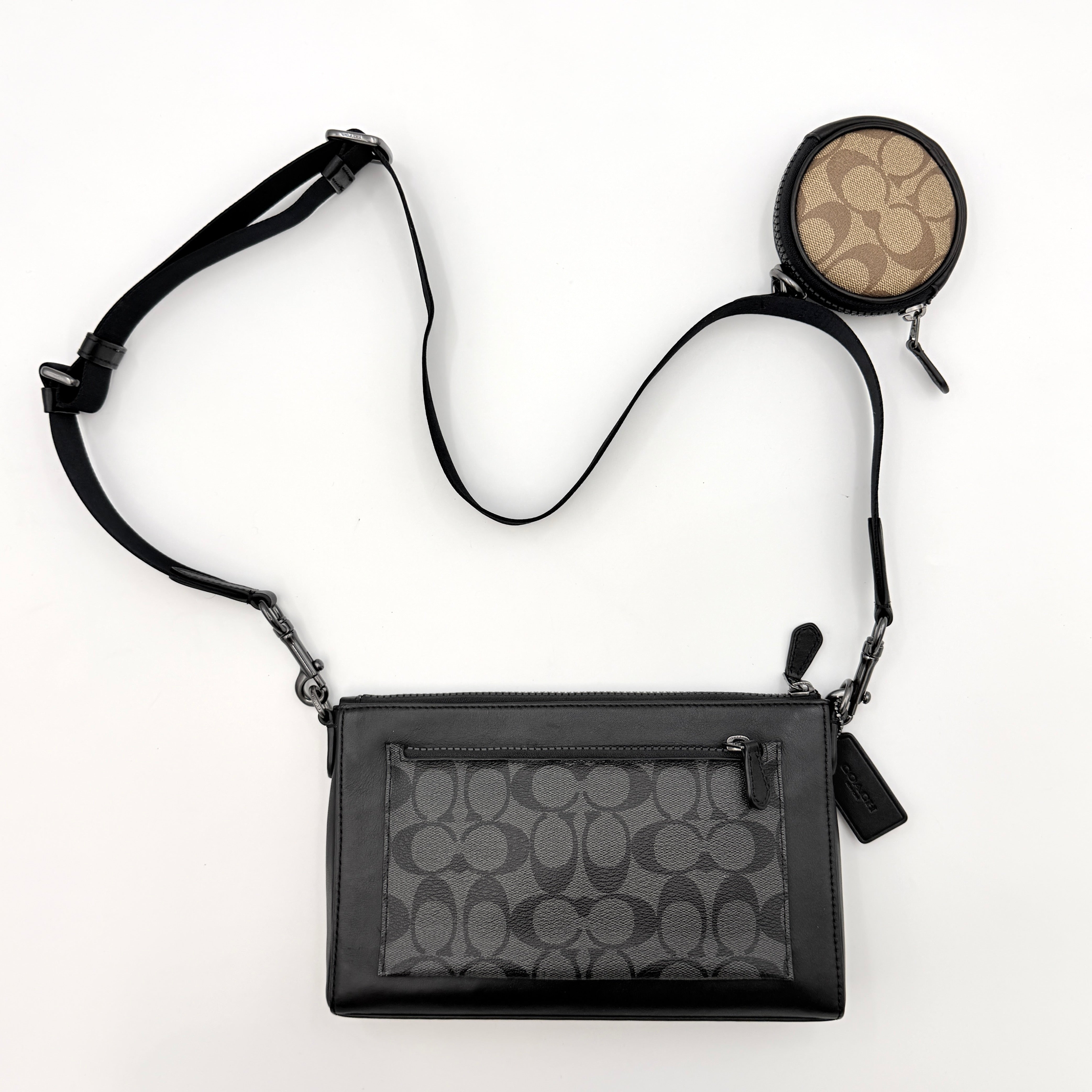 Coach Signature Holden Crossbody Bag in black with beige round coin pouch, featuring coated canvas and leather panels against a white background.