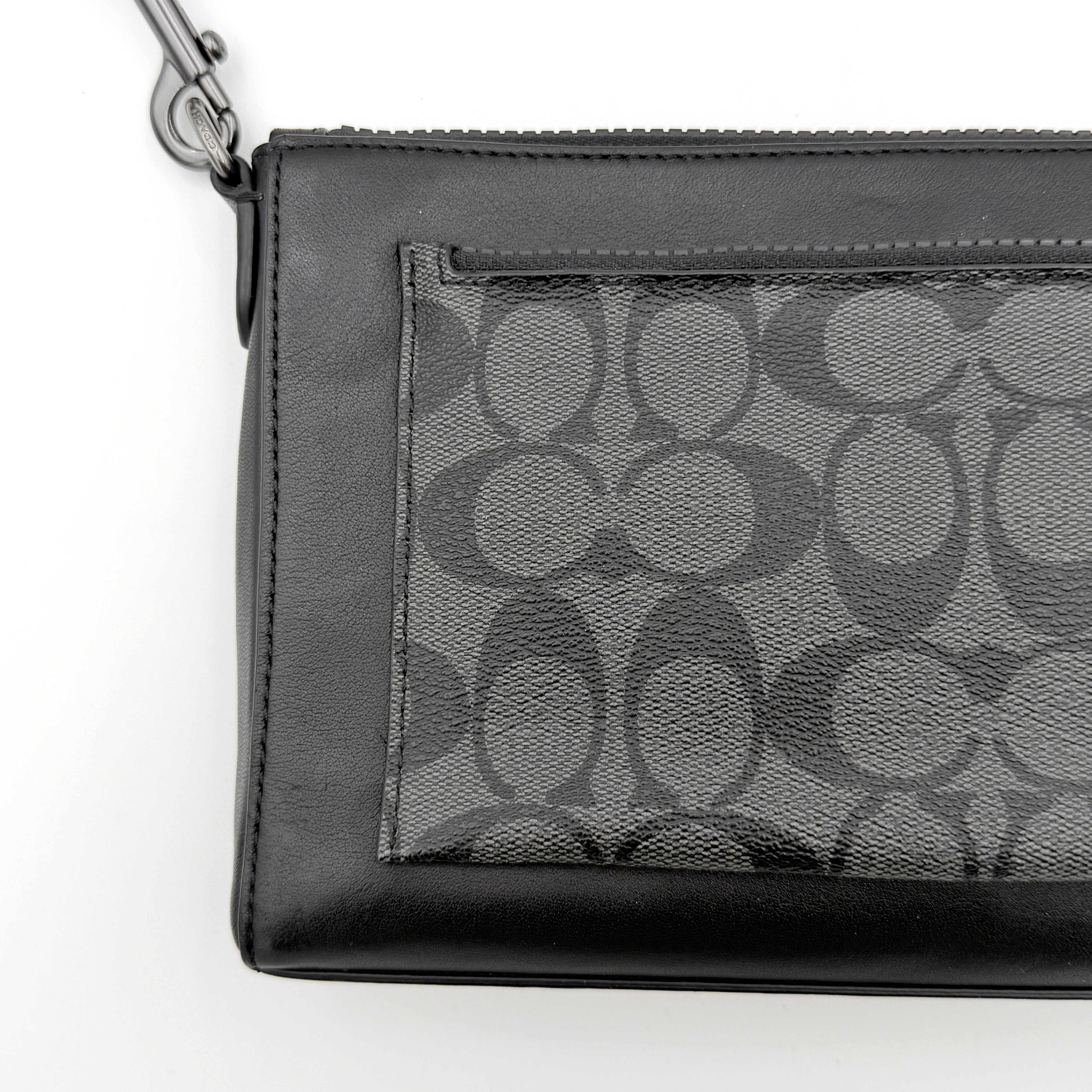 Coach Signature Holden Crossbody Bag in black with beige round coin pouch, featuring coated canvas and leather panels against a white background.