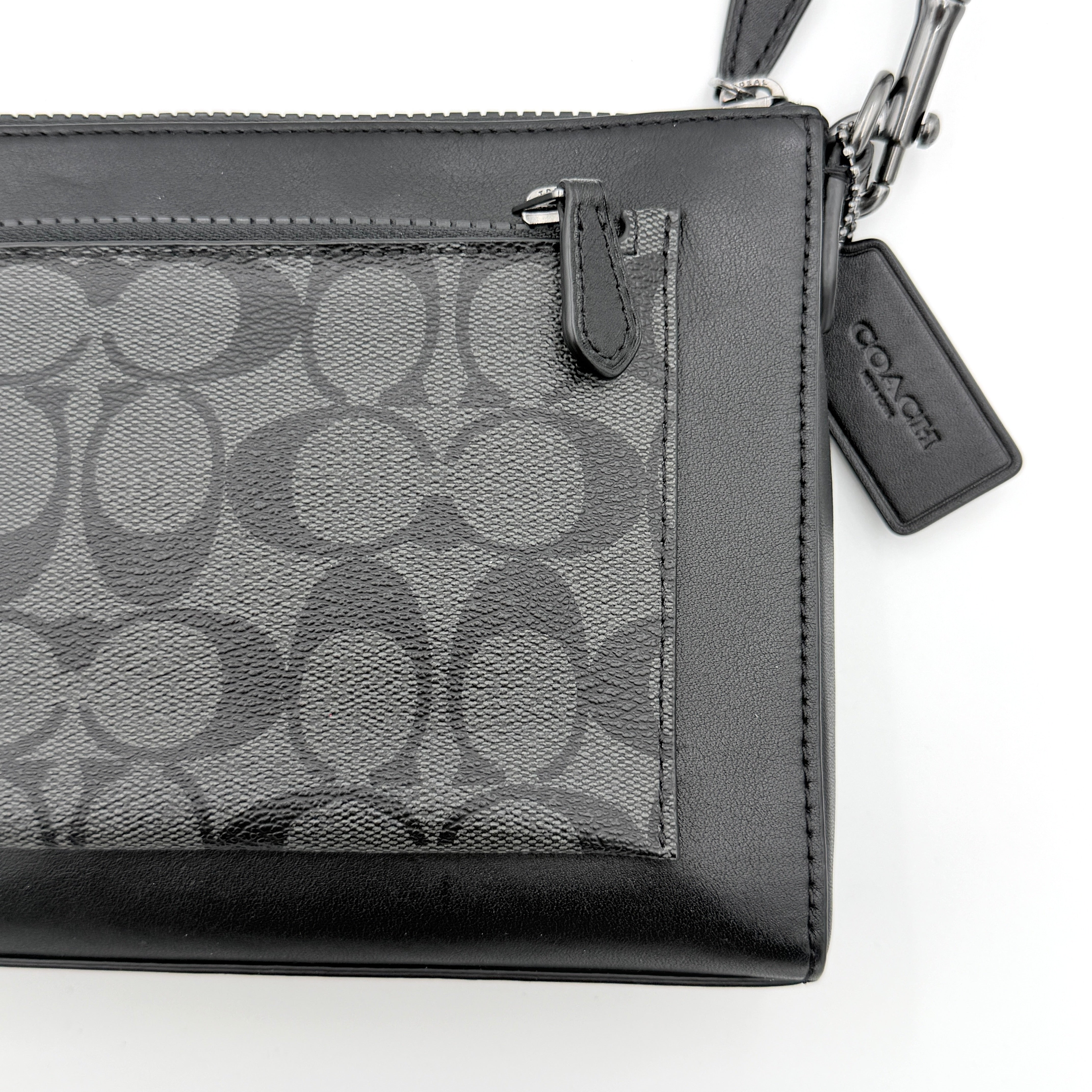 Coach Signature Holden Crossbody Bag in black with beige round coin pouch, featuring coated canvas and leather panels against a white background.