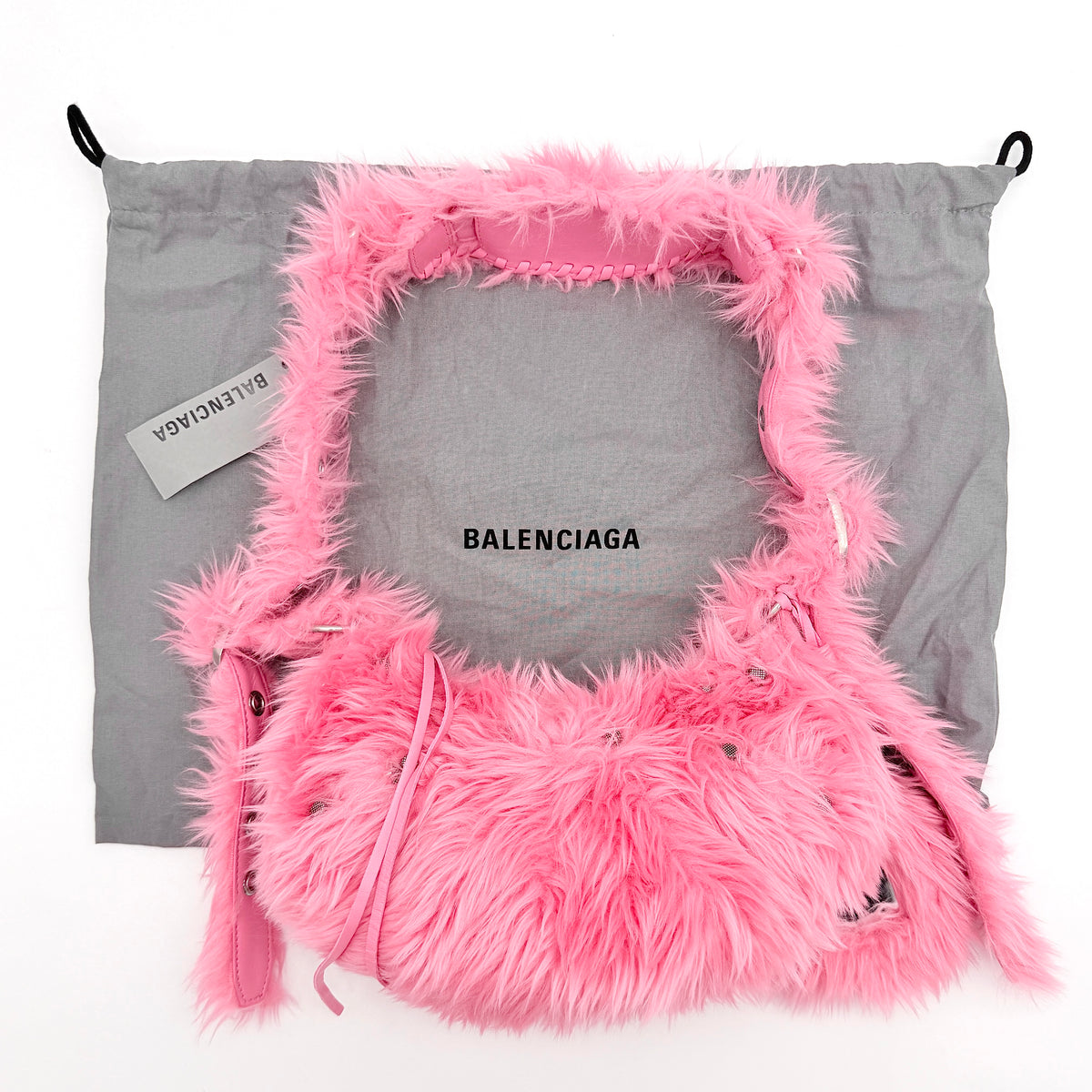 Balenciaga XS Le Cagole Shoulder Bag in sweet pink faux fur with heart-shaped mirror charm and silver hardware, styled on its original dust bag.