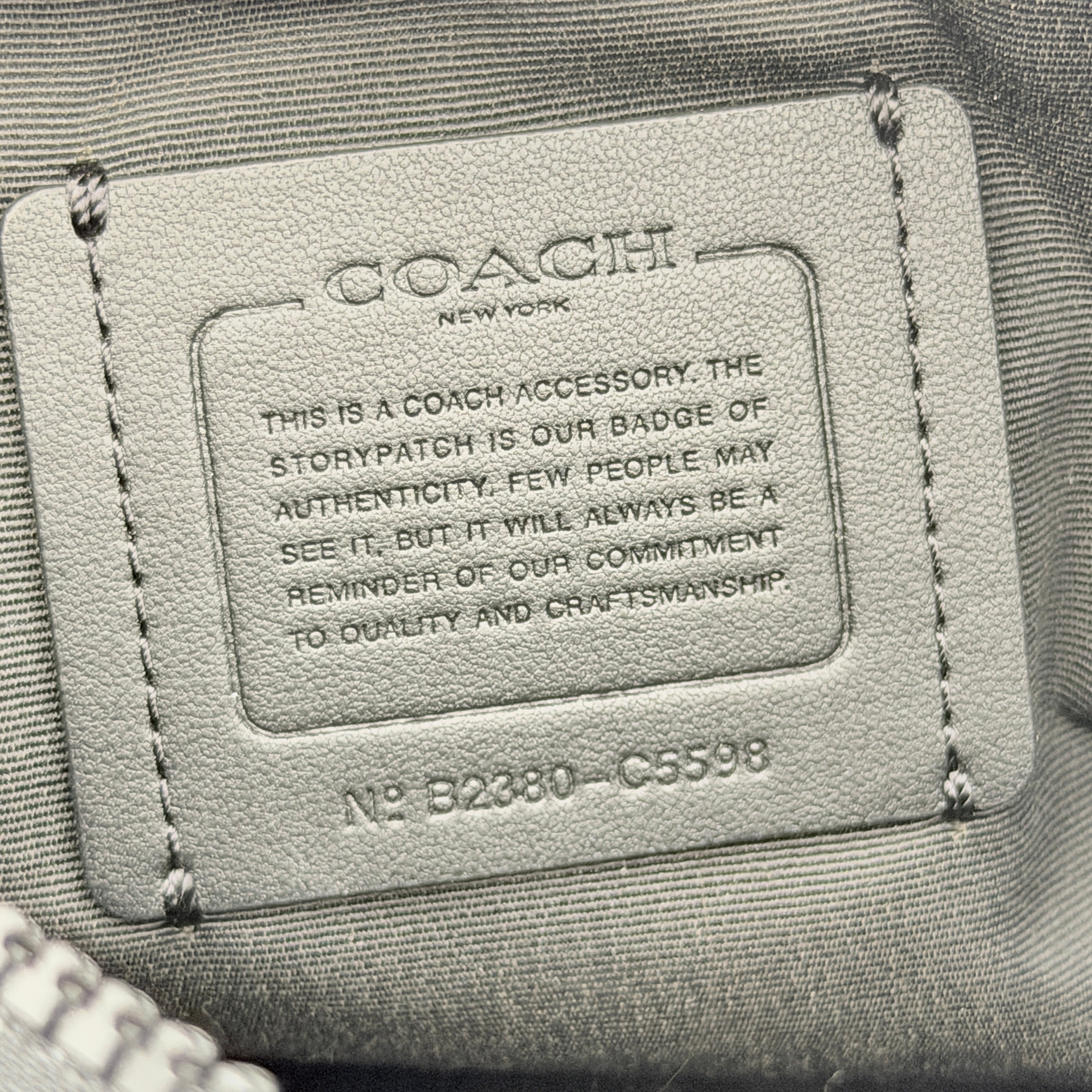 Coach Signature Holden Crossbody Bag in black with beige round coin pouch, featuring coated canvas and leather panels against a white background.