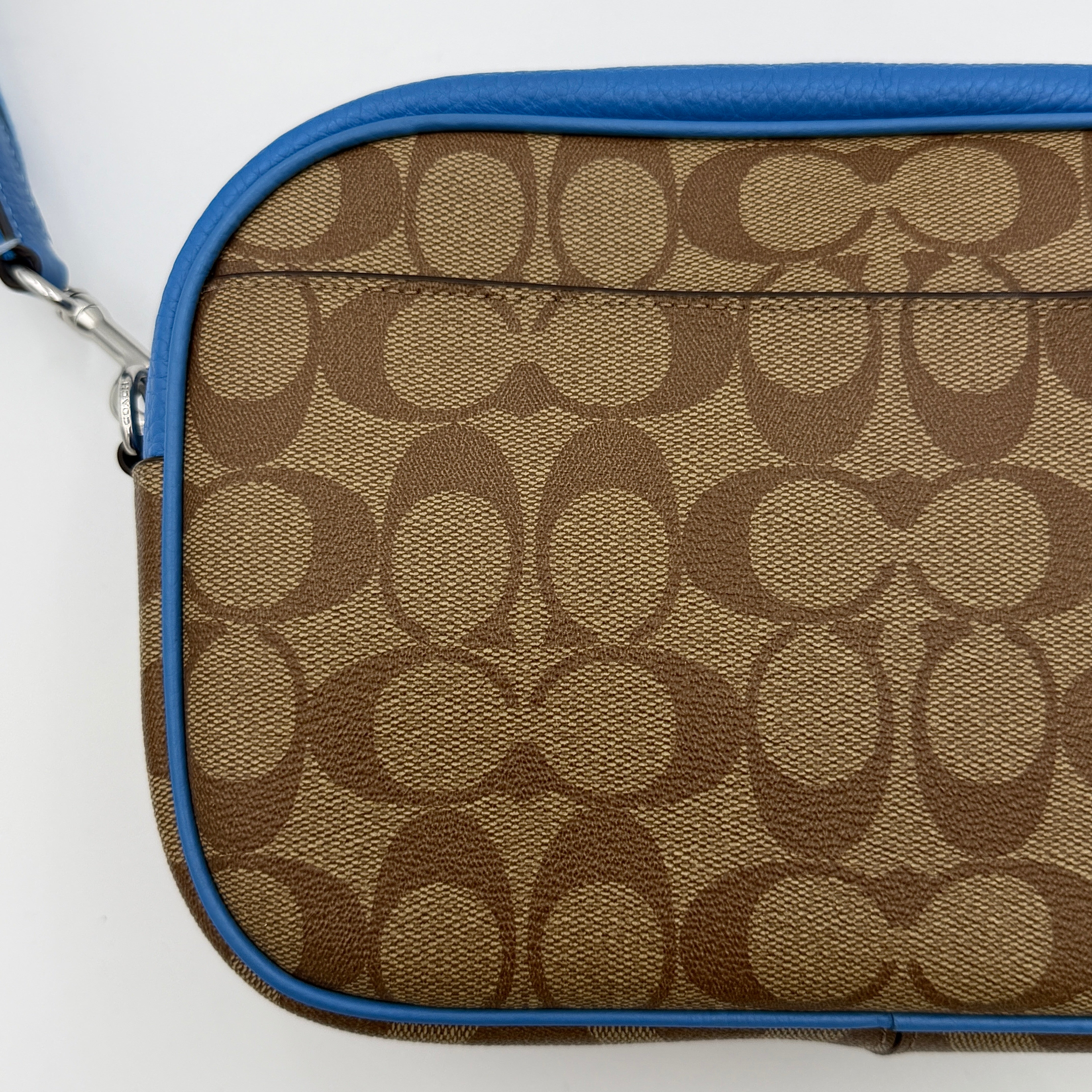 Coach Signature Jamie Crossbody Bag in beige and blue with bold logo webbing strap and blue leather trim, photographed against a white background.