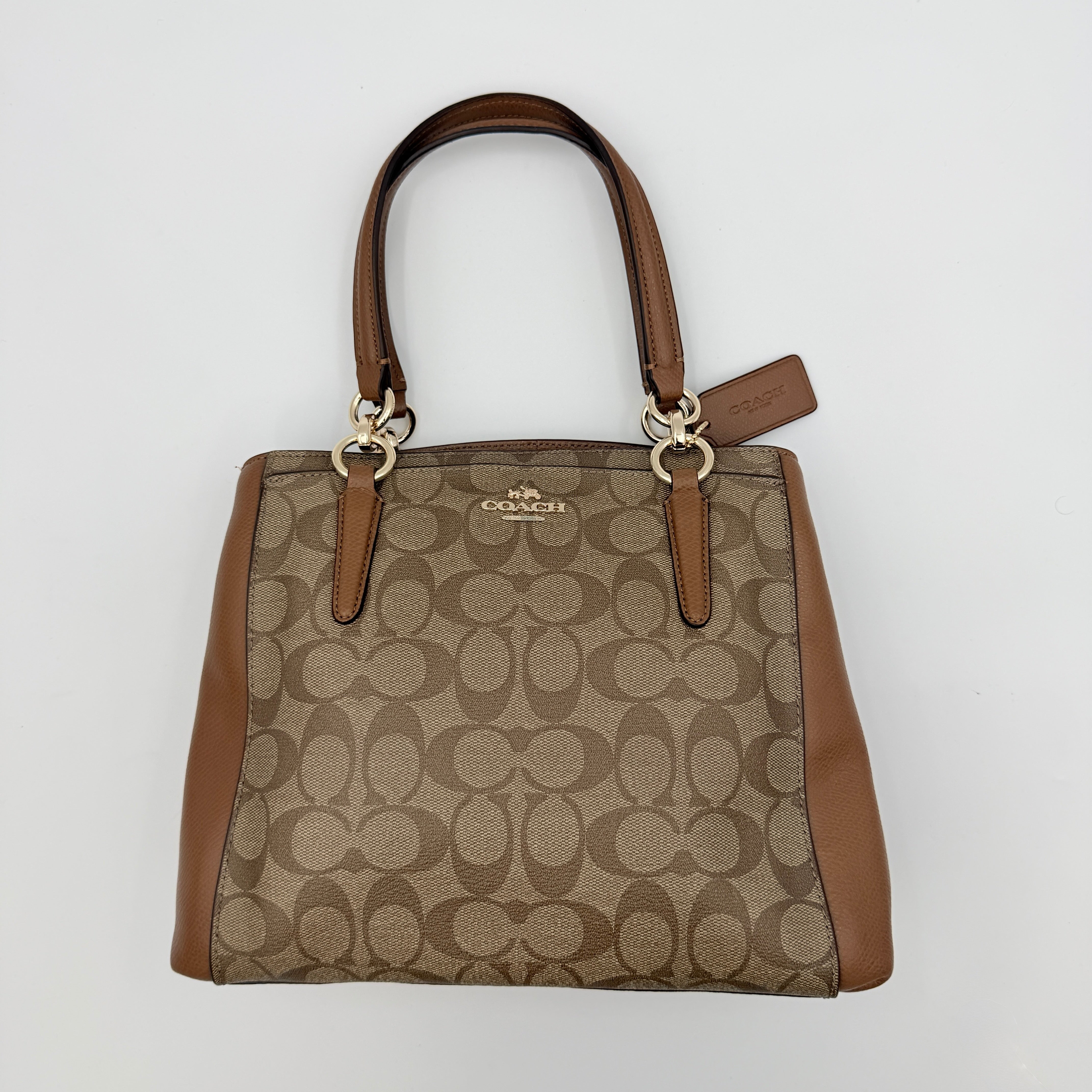 Coach Mini Christie Carryall in brown canvas and leather, shown with top handles and detachable strap.