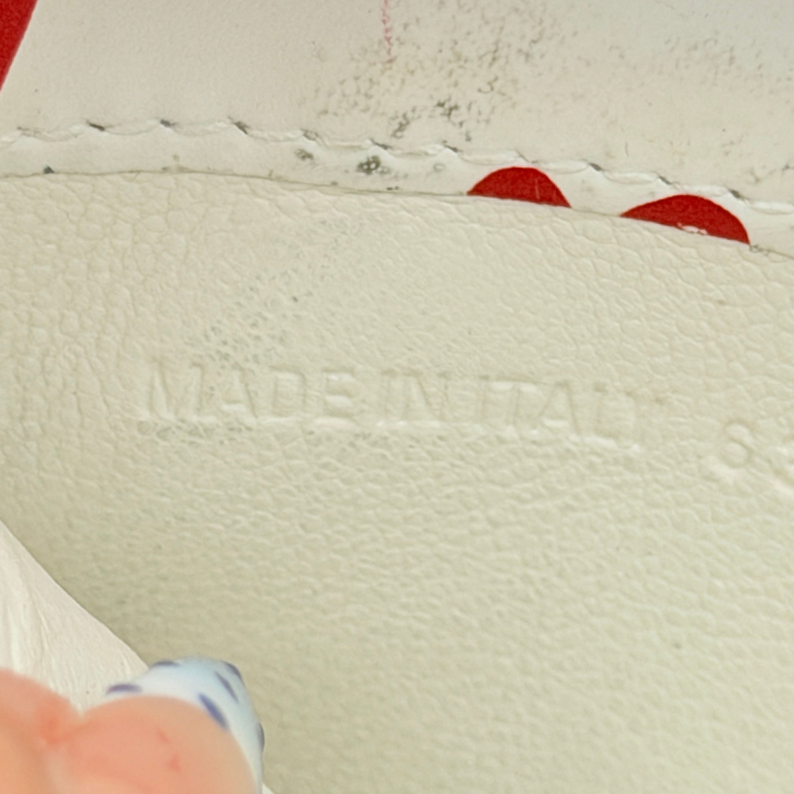 Balenciaga white leather card holder with playful red hearts and zip closure, set against a clean background.