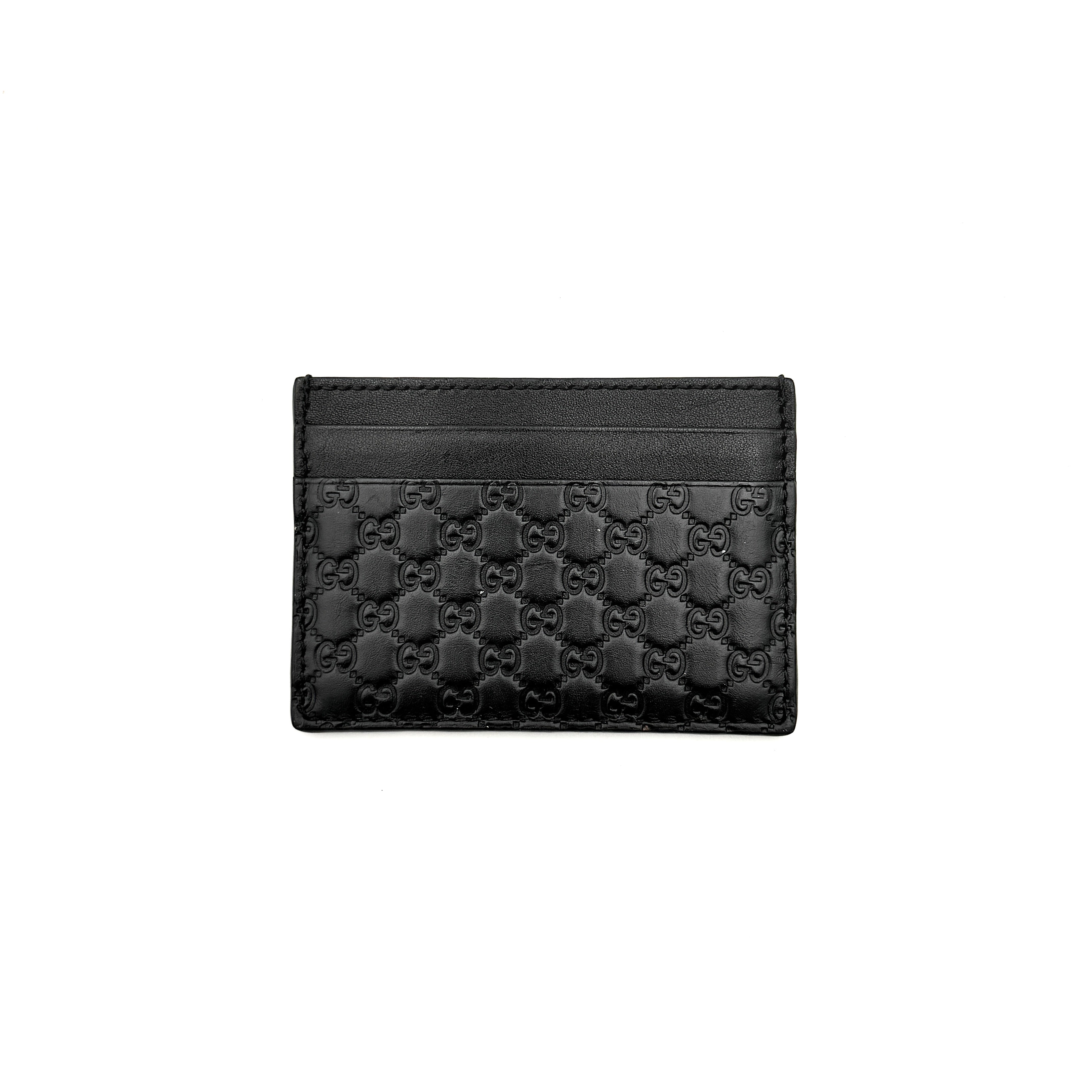 Gucci GG Microguccissima card holder in black leather with embossed micro GG motif, compact silhouette and refined finish.