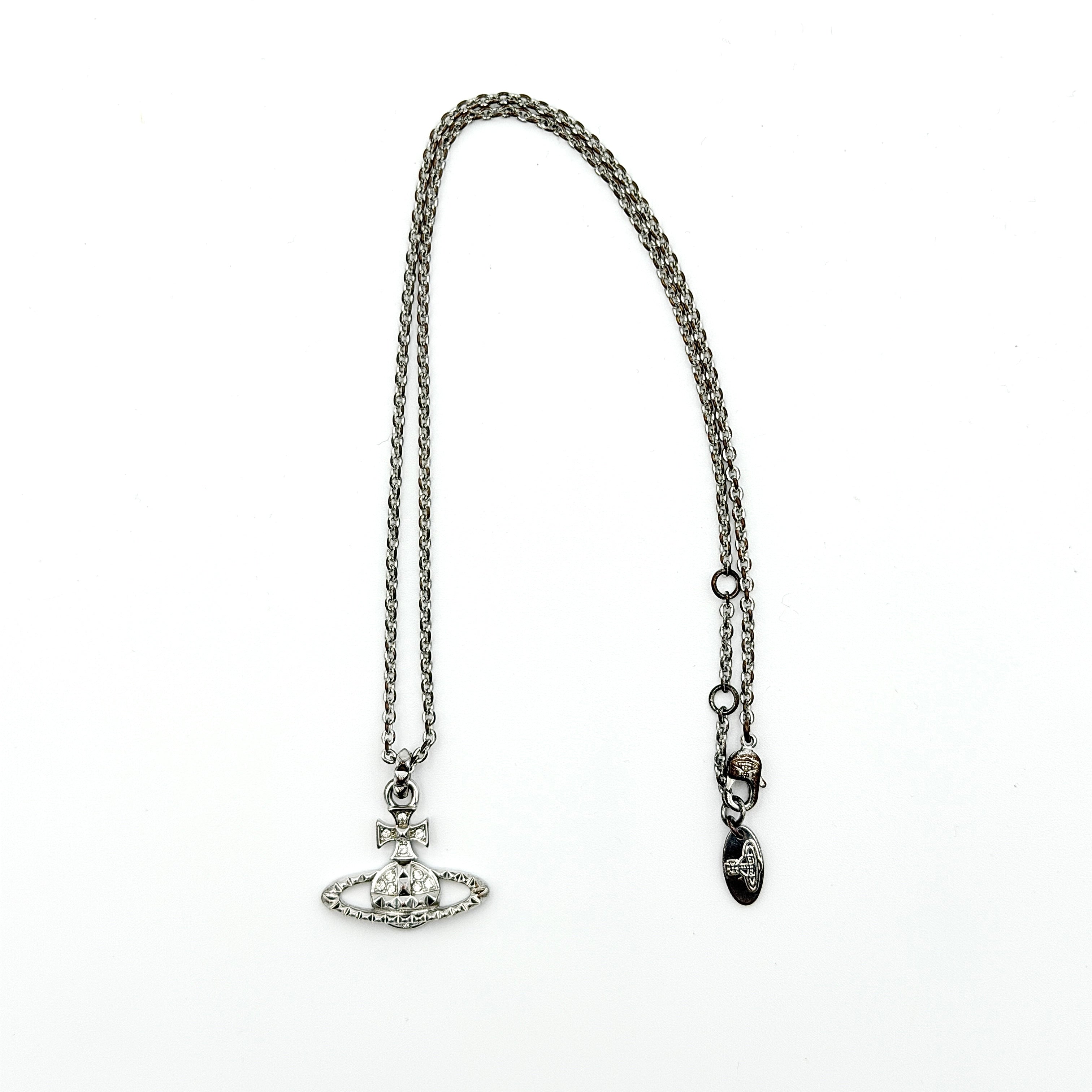 Vivienne Westwood silver orb necklace with crystal-studded Saturn motif on a textured chain, displayed against a clean background.