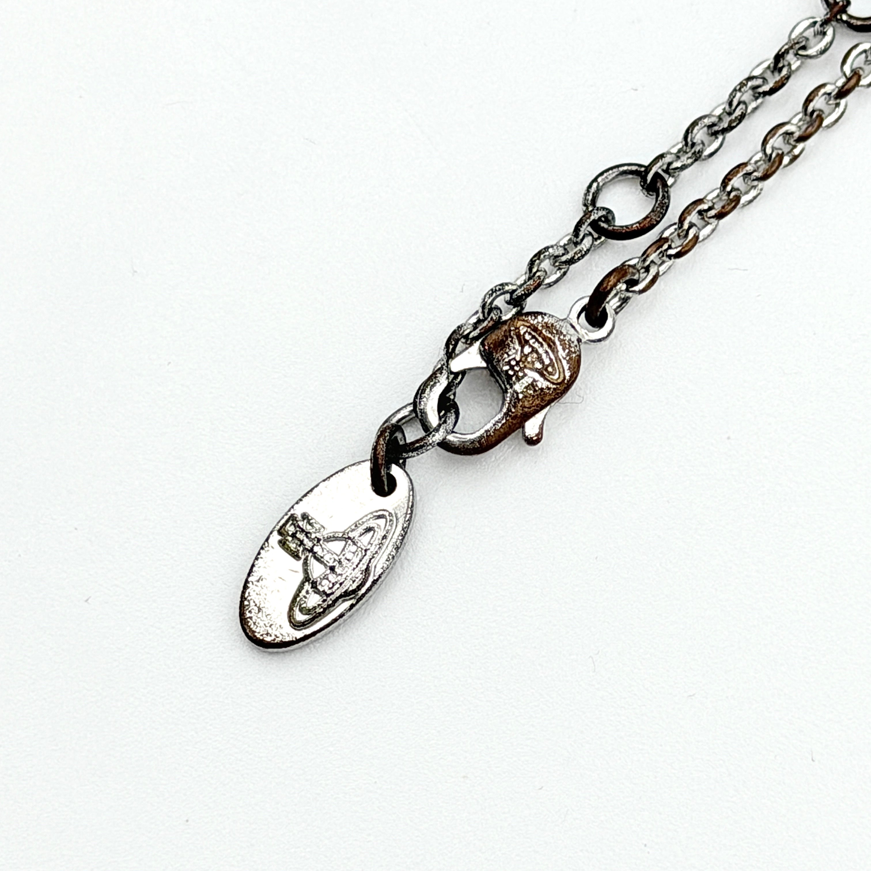 Vivienne Westwood silver orb necklace with crystal-studded Saturn motif on a textured chain, displayed against a clean background.