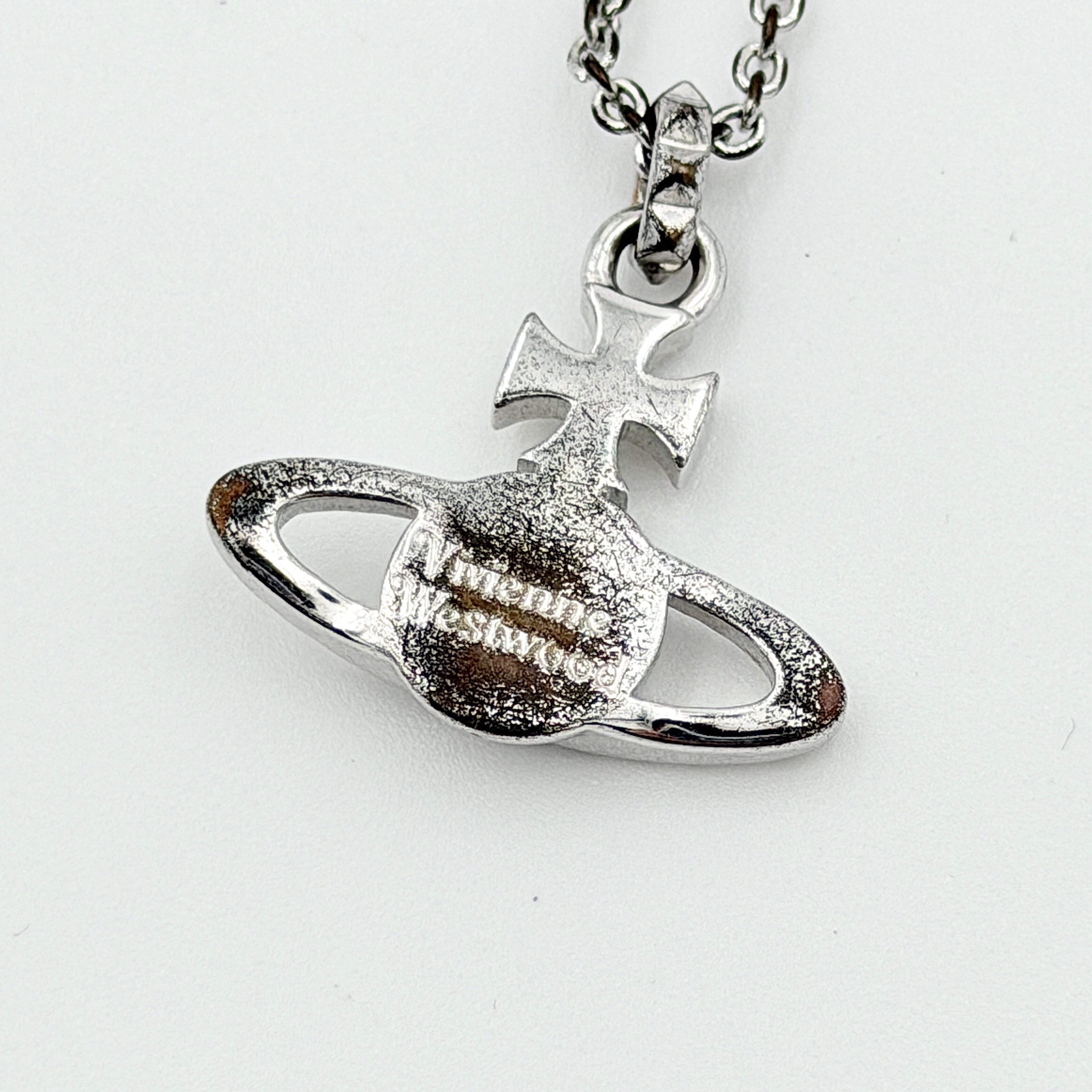 Vivienne Westwood silver orb necklace with crystal-studded Saturn motif on a textured chain, displayed against a clean background.