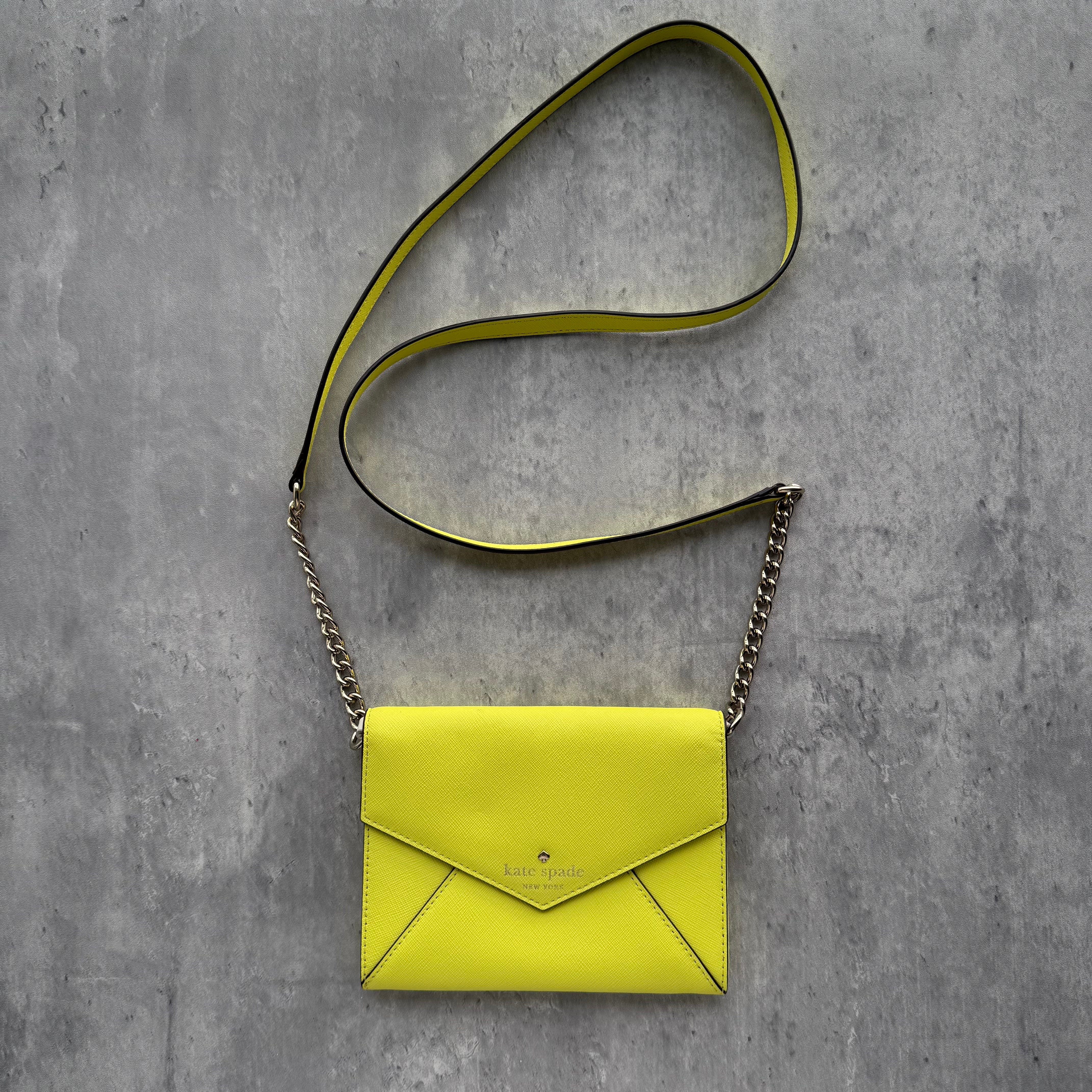 Kate Spade Envelope Crossbody Bag Yellow in saffiano leather with chain and leather strap, envelope silhouette, and polka-dot fabric lining.