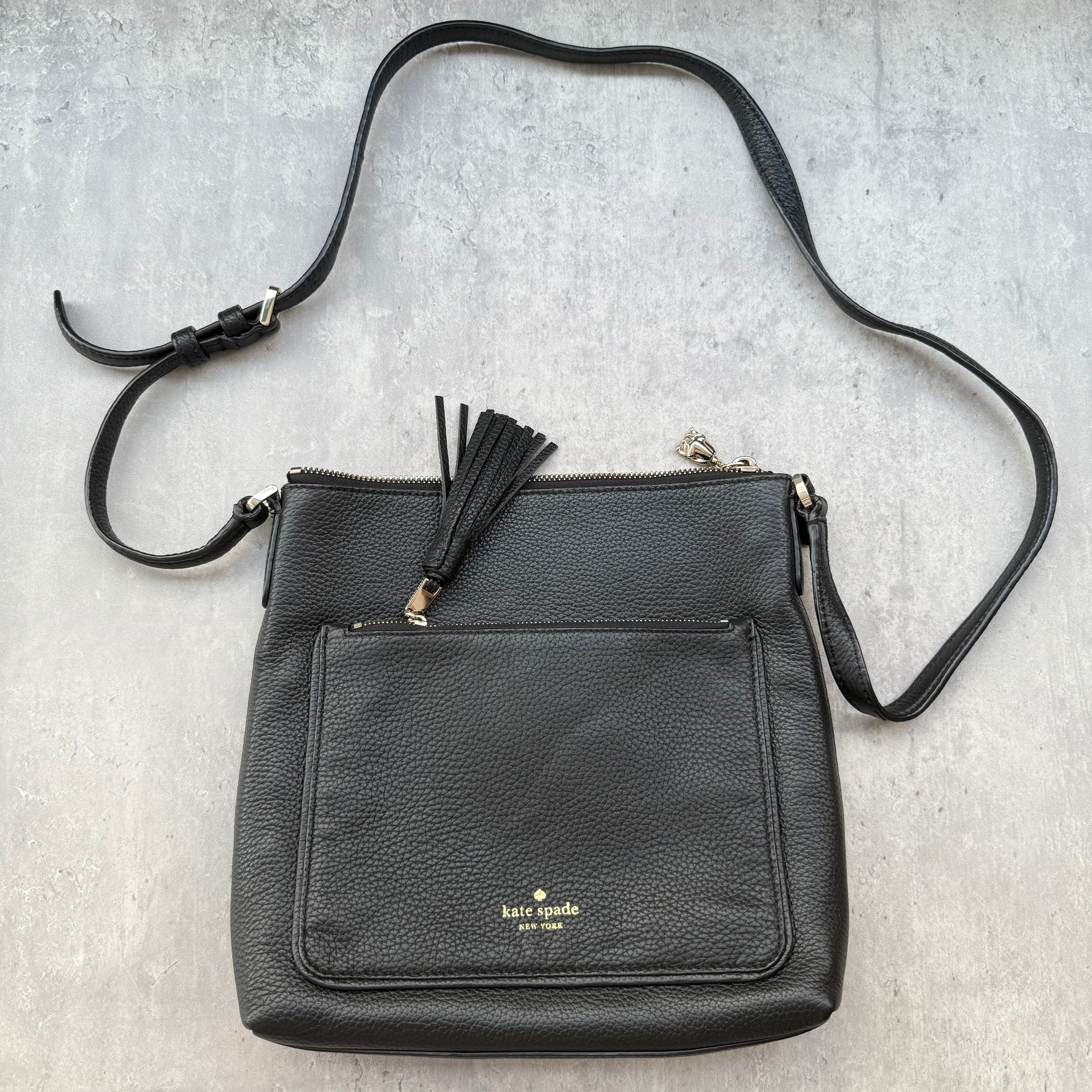 Kate Spade New York black pebbled leather crossbody bag with tassel zip pocket and gold-tone hardware