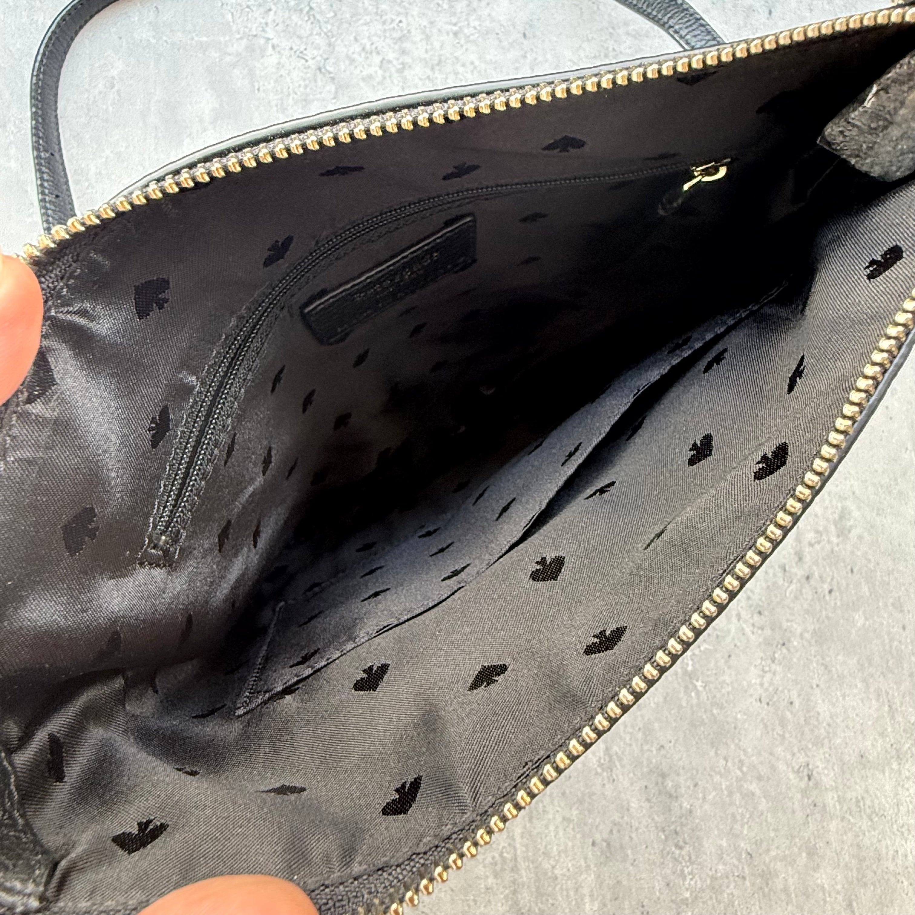 Kate Spade New York black pebbled leather crossbody bag with tassel zip pocket and gold-tone hardware