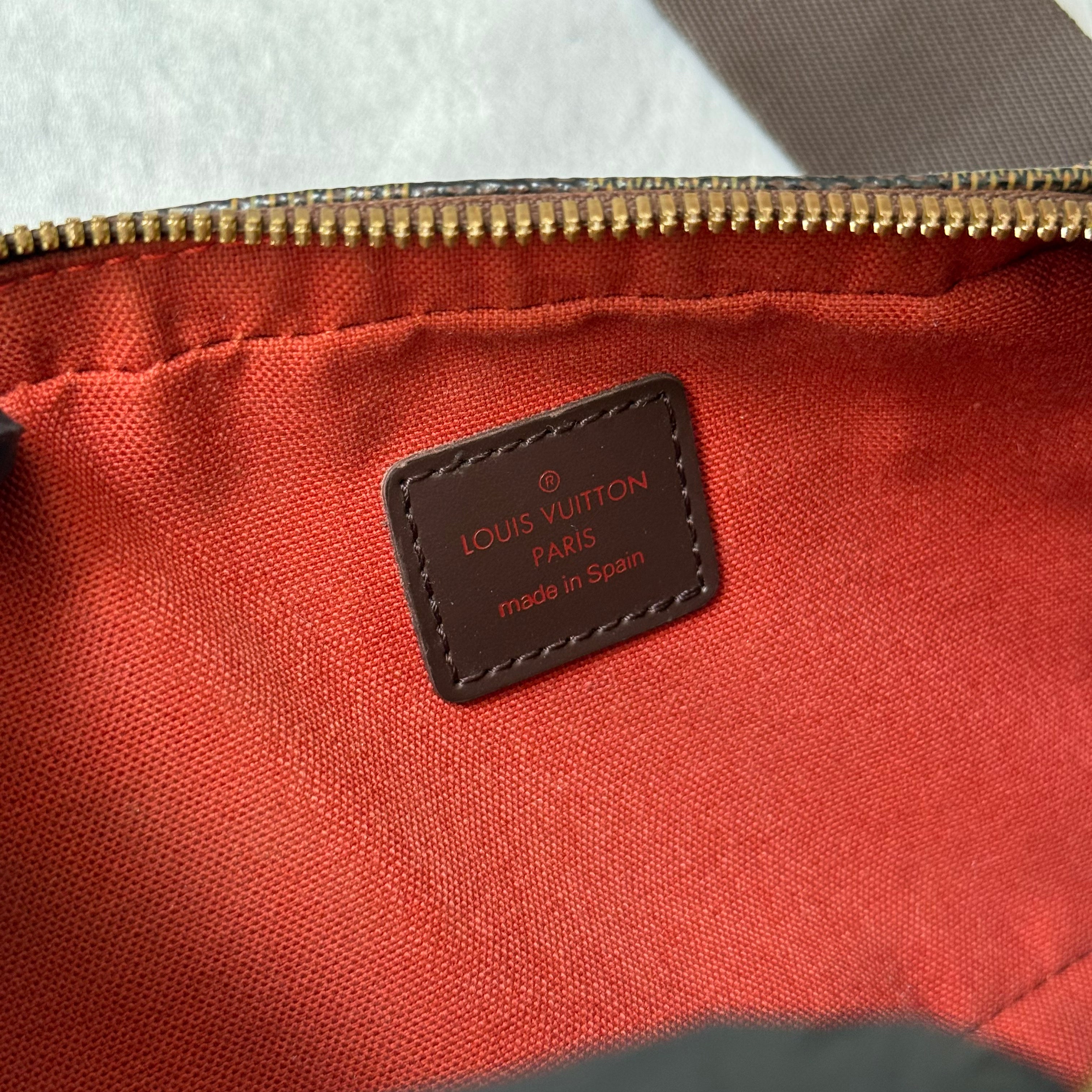 Louis Vuitton Geronimos Bag in brown Damier Ebene canvas with adjustable strap, red interior, and zip closure.