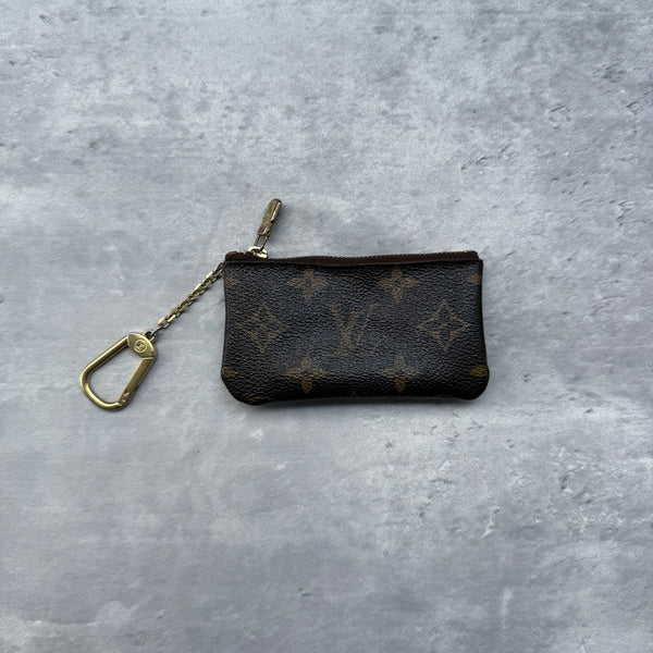 Louis Vuitton Monogram Coin Purse, crafted in brown coated canvas with gold-tone zipper and hook clasp chain.