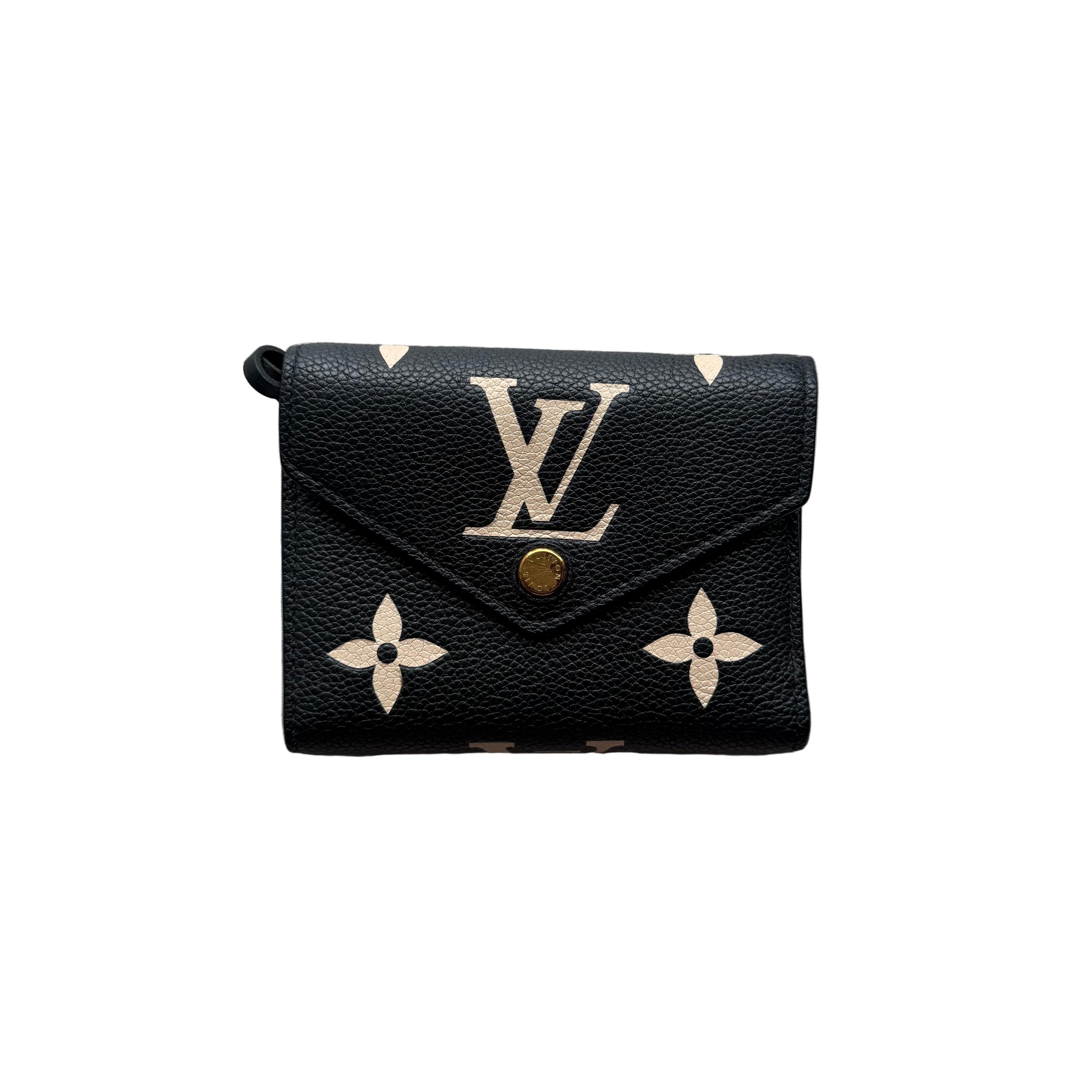 Louis Vuitton Victorine Wallet in black Monogram Empreinte leather with beige oversized monogram, gold-tone snap button, and zip coin pocket.