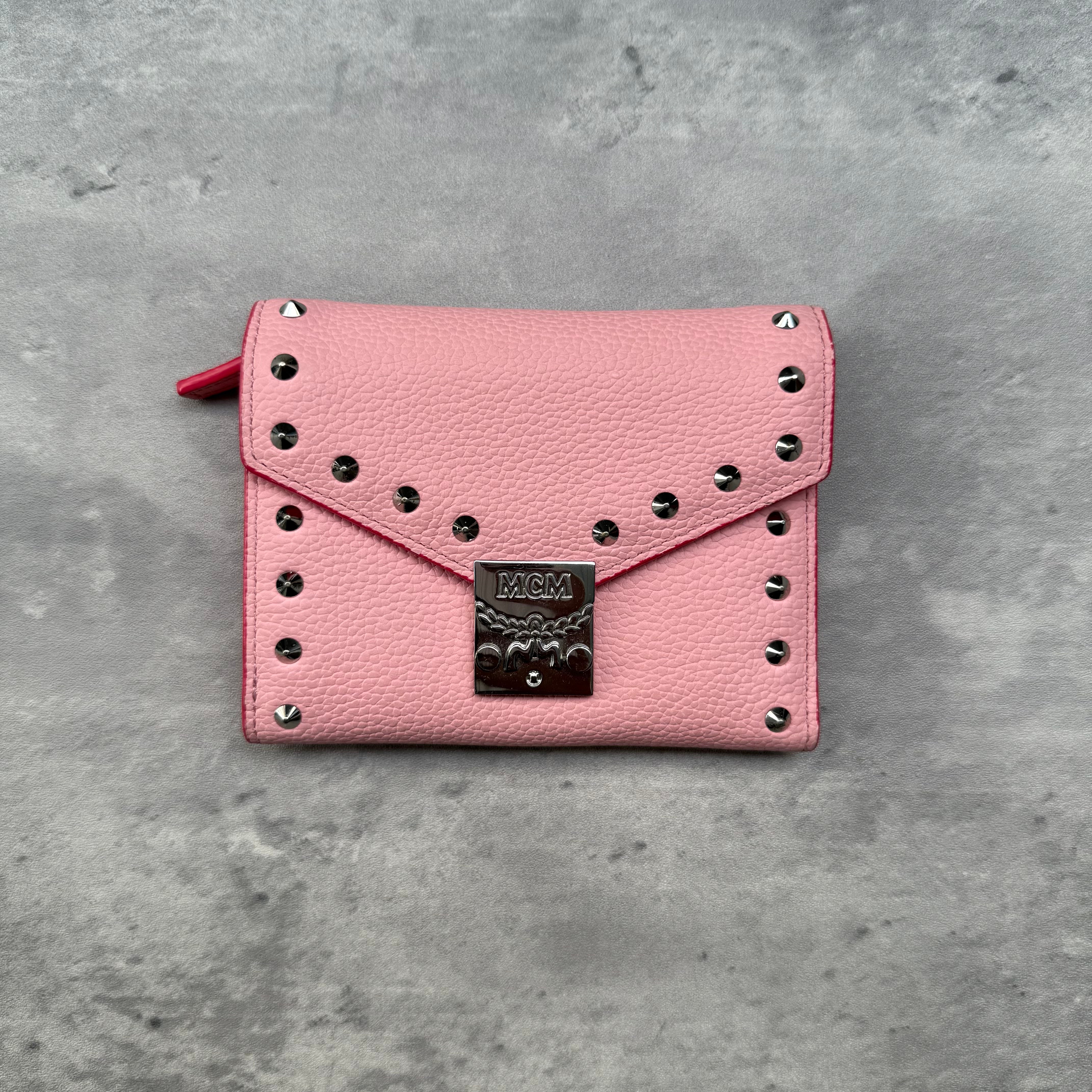 MCM Y2K Patricia Studded Mini Wallet in pink grained leather with metallic studs, push-lock closure, and slots for cards and cash.