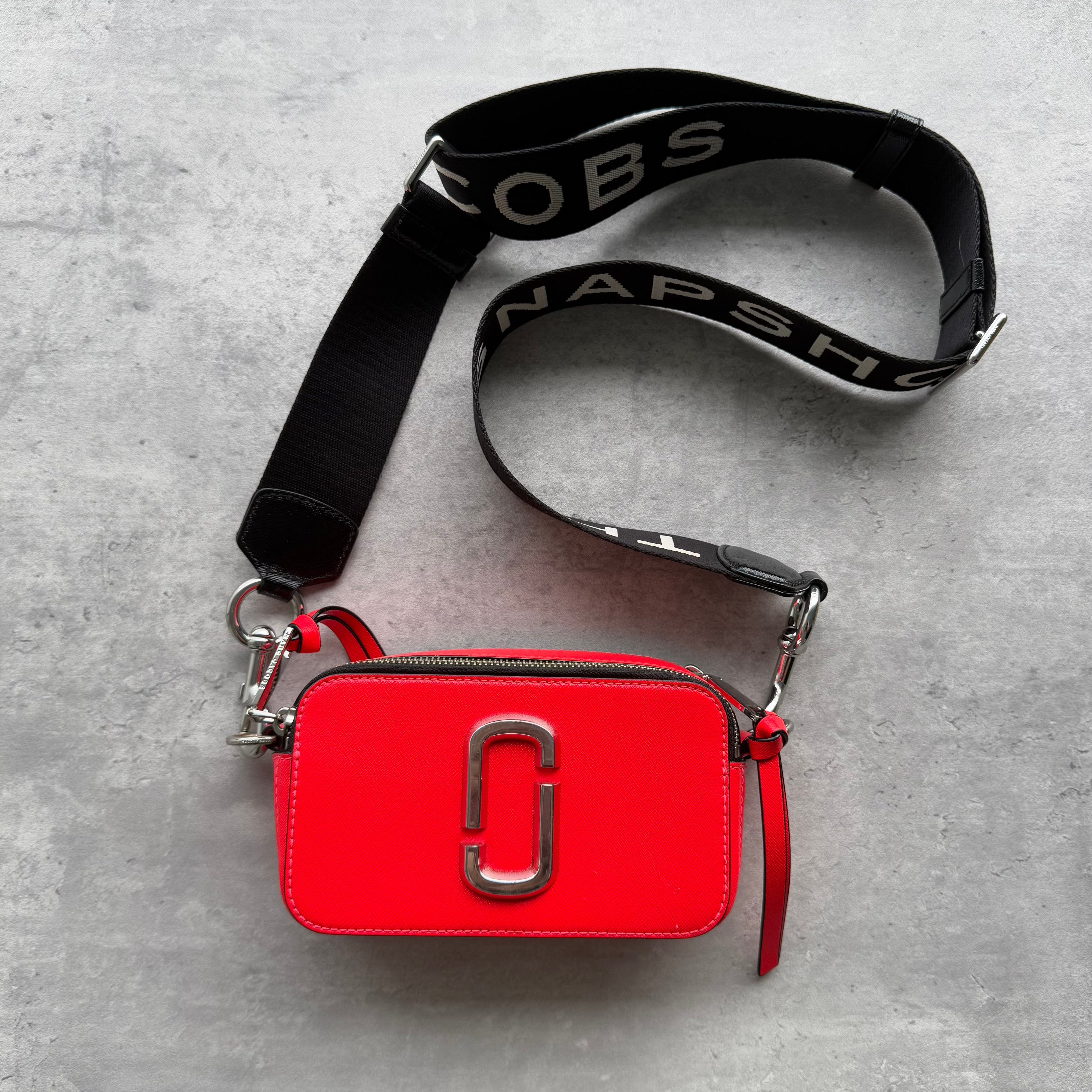 Marc Jacobs The Snapshot Crossbody Bag in red leather with silver double-J hardware, detachable wide logo strap, and dual zip closure.