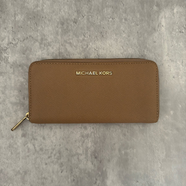 Michael Kors Jet Set Travel Zip-Around Saffiano Leather Continental Wallet in brown, featuring a gold-tone MK logo and zip-around closure.