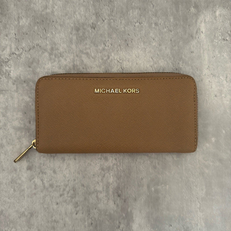 Michael Kors Jet Set Travel Zip-Around Saffiano Leather Continental Wallet in brown, featuring a gold-tone MK logo and zip-around closure.