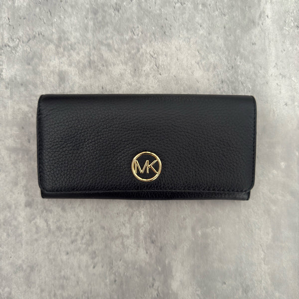 Michael Kors MK Gold Logo Bifold Long Wallet in black pebbled leather, featuring a structured silhouette with a gold-tone MK logo and a snap button closure.