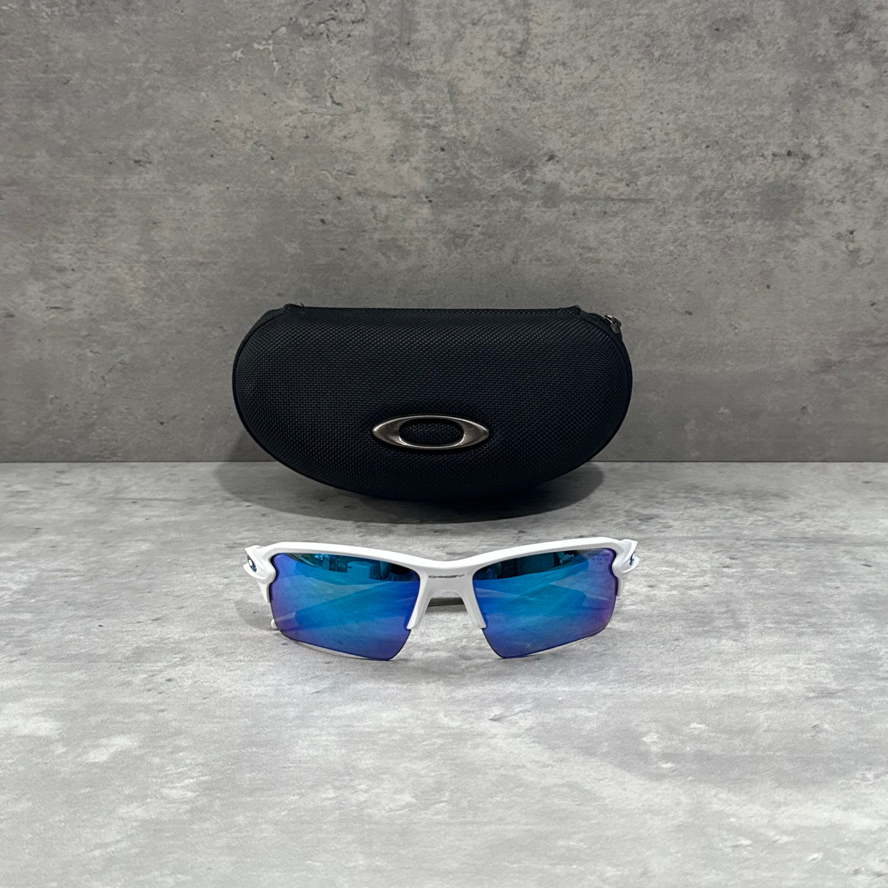 Oakley FLAK Prizm Sunglasses with sapphire blue lenses and white frame featuring wraparound sport design.