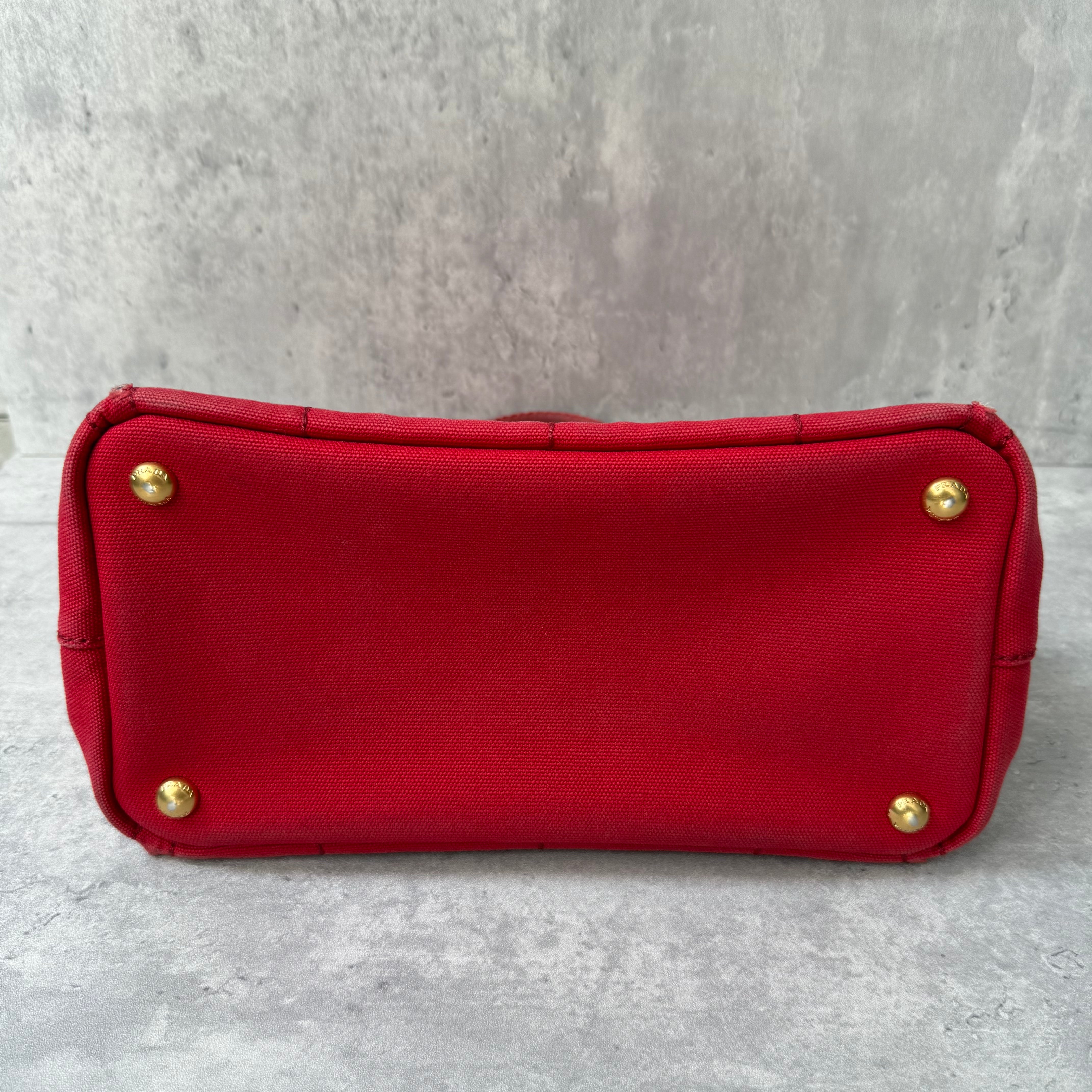 Prada Canapa Tote Bag in red canvas with black logo embroidery, featuring a structured silhouette and dual top handles for effortless style.