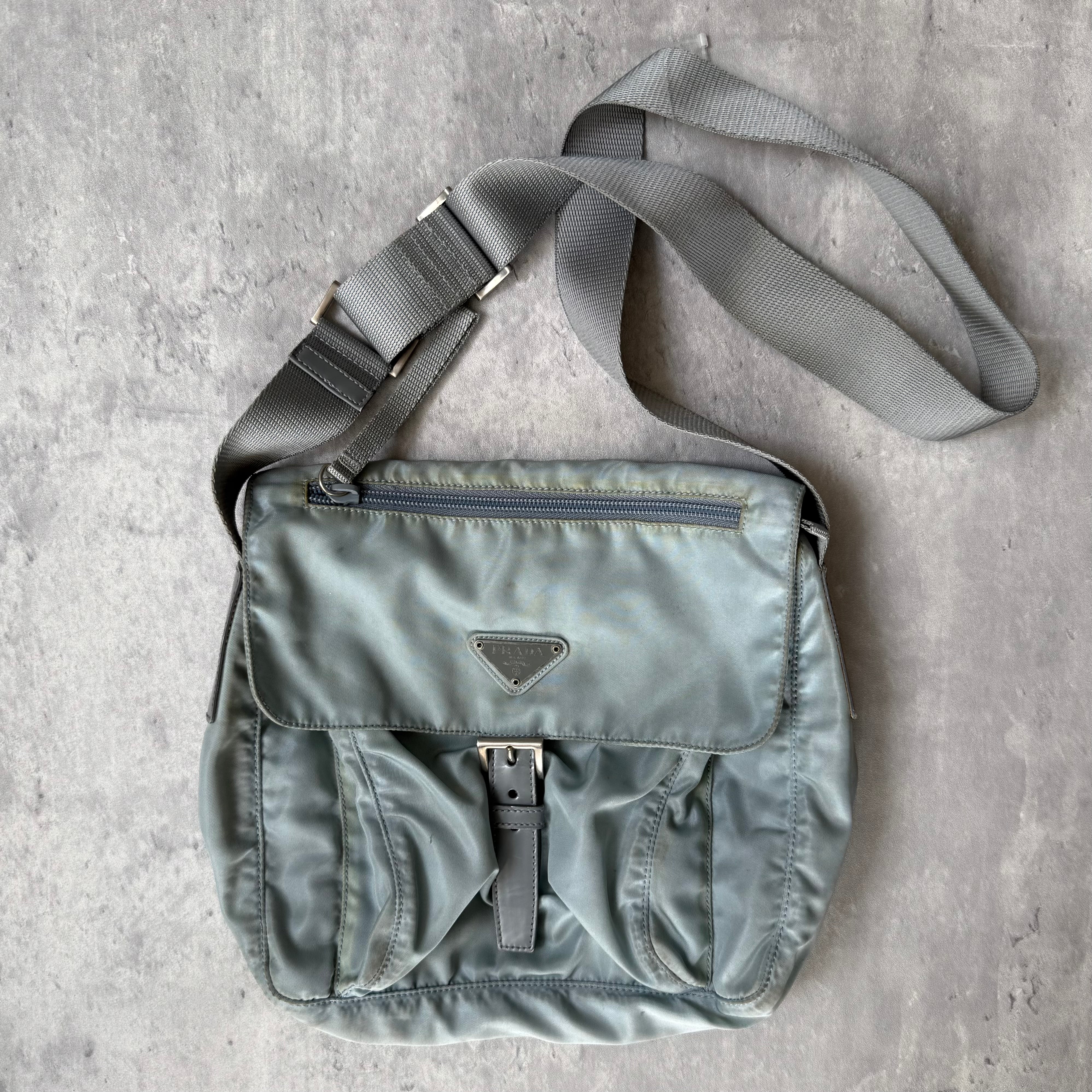 Prada Nylon Front Buckle Shoulder Bag in light blue with grey strap, zip and buckle compartments, and Prada logo plaque.