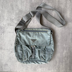 Prada Nylon Front Buckle Shoulder Bag in light blue with grey strap, zip and buckle compartments, and Prada logo plaque.